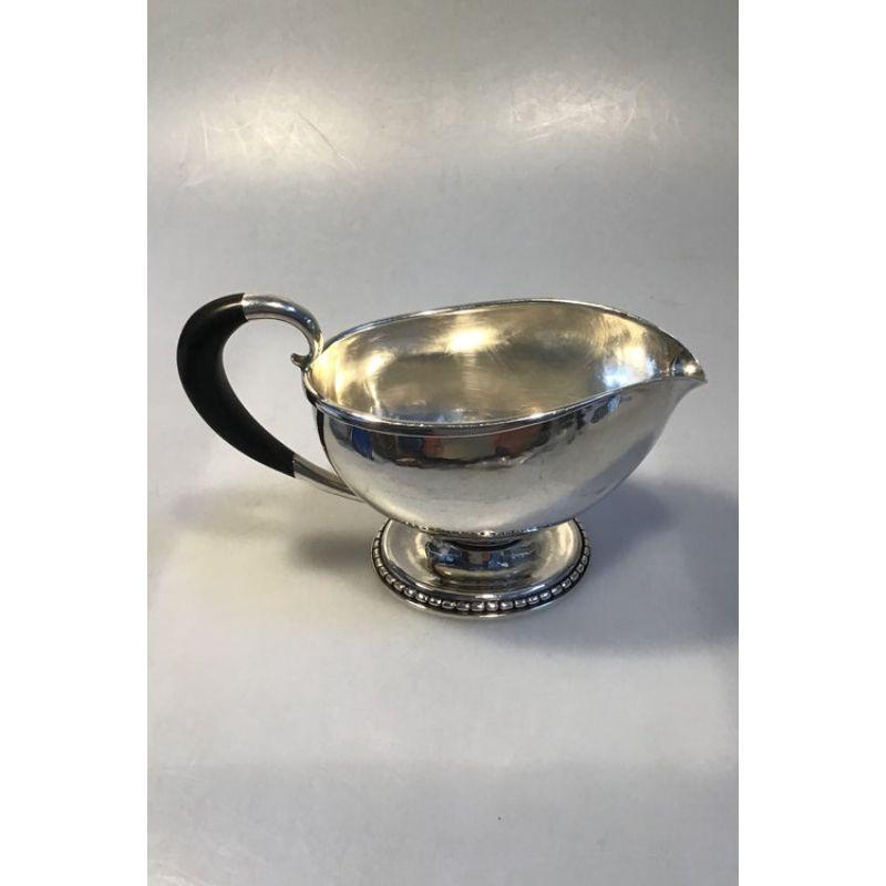Georg Jensen sterling silver sauce pitcher no. 290B.

Measures 9 cm x 18 cm x 11 cm / (3 35/64 in x 7 3/32 in x 421/64 in) Weight 363.1 gr / 12.81 oz