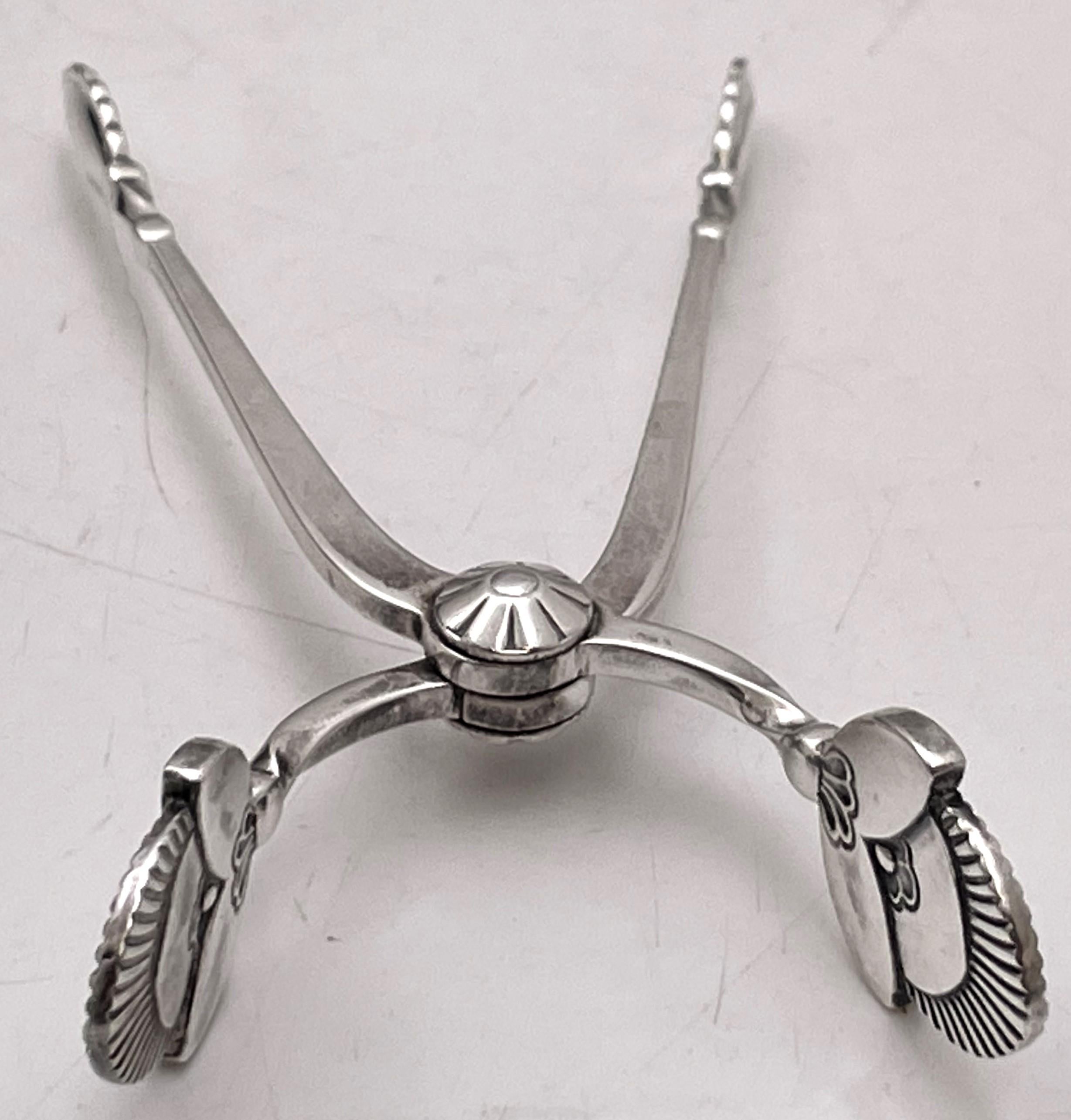Georg Jensen sterling silver sugar tongs, in the celebrated Cactus pattern, measuring 3 3/4'' in length by 1 7/8'' in depth, and bearing hallmarks as shown. 

Designed in 1930 by Gundorph Albertus, the Cactus pattern demonstrates Art Deco’s taste