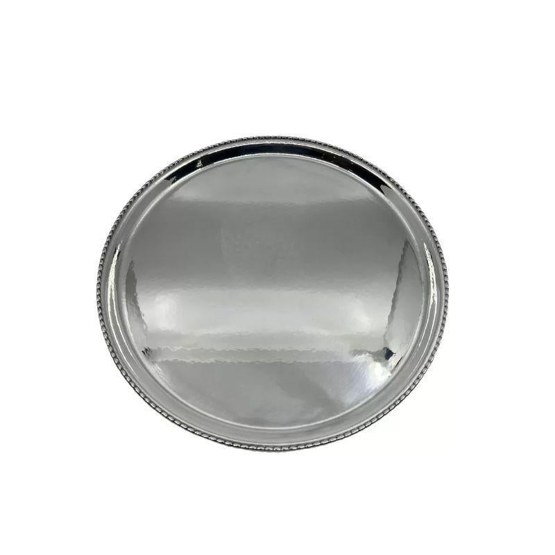 A vintage sterling silver Georg Jensen circular tray, design #209N by Georg Jensen from circa 1916. An understated design with a beautiful hammered surface, the side is slightly raised and has a pearled edge. Ideal for use as a serving platter or