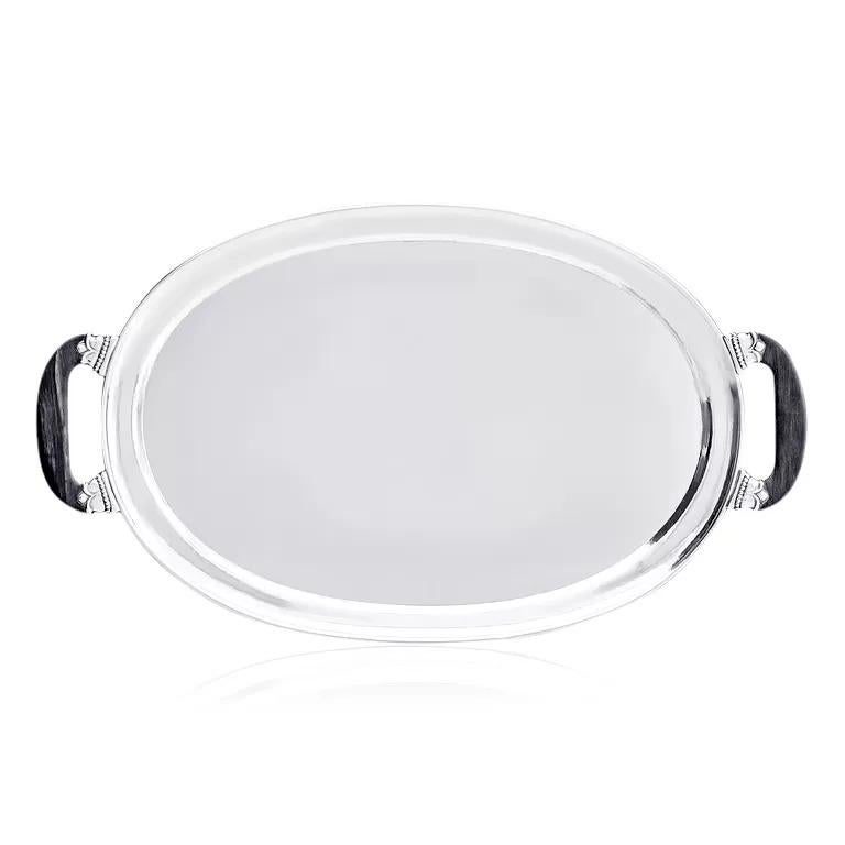 A stunning large sterling silver tray by Georg Jensen, model #80, designed in 1915. This elegant oval tray features hand-hammered craftsmanship with a raised rim and border. The tray is equipped with two opposing ebony handles, mounted on sterling