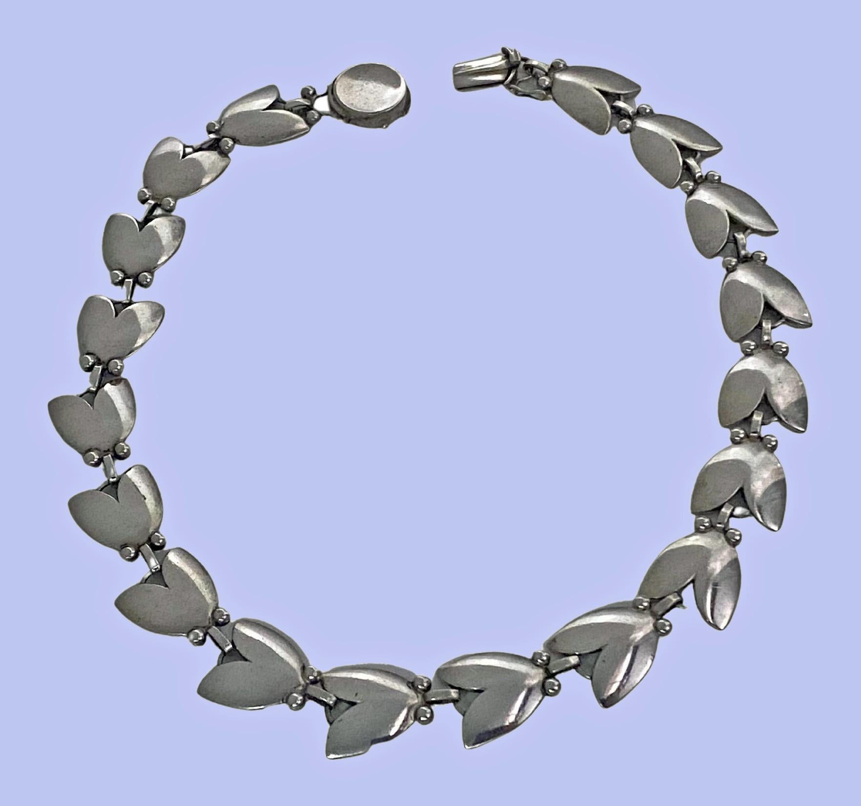 Georg Jensen Sterling Silver Tulip Necklace No. 66 by Harald Nielsen C.1950. The Necklace comprising 18 links of a tulip shape leaf each accented at the base with two berries, terminating with tongue and box clasp fastener, safety catch attached.