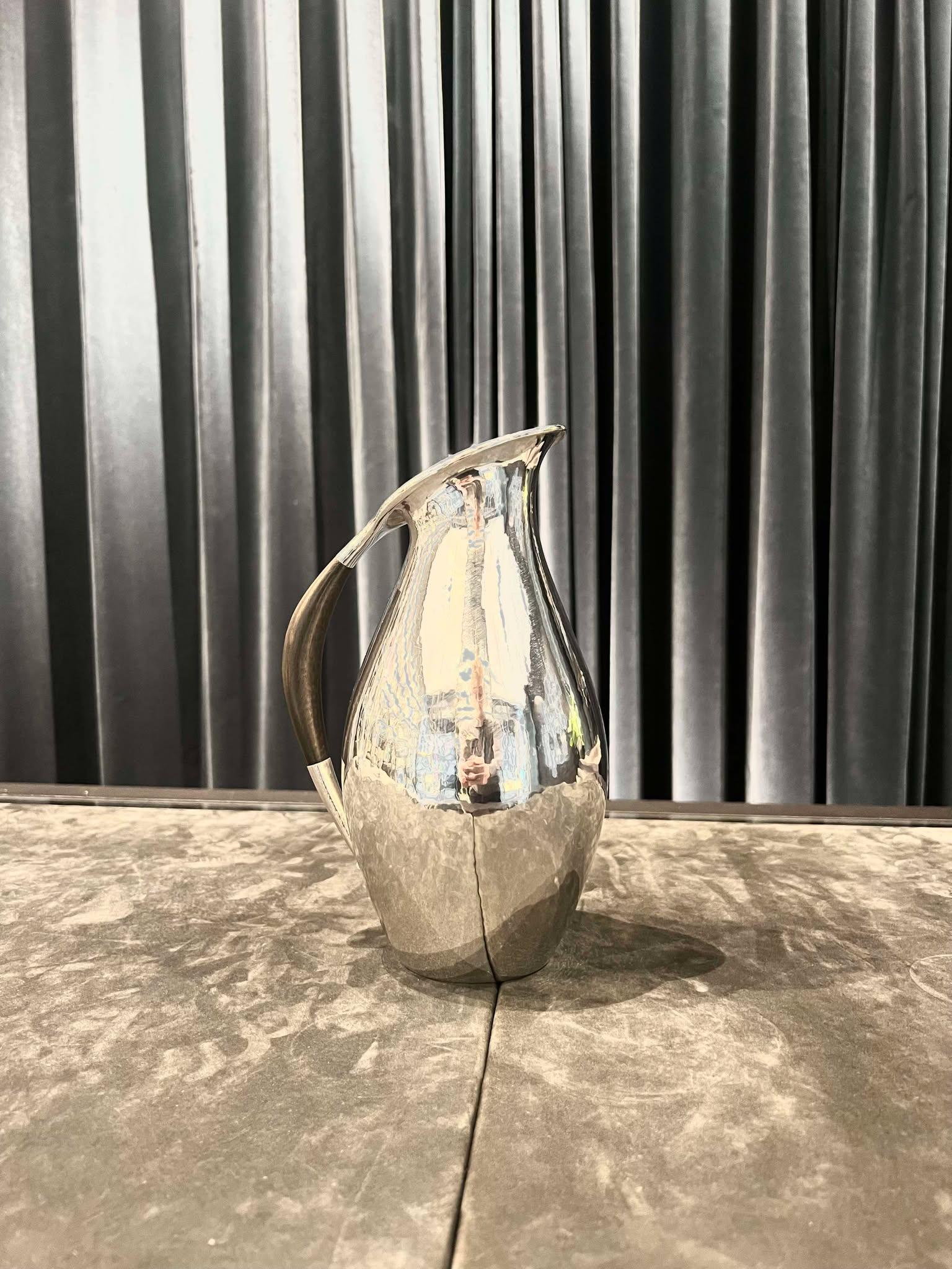 Jarra vintage Georg Jensen de plata de ley con asa de ébano, diseño nº 432E de Johan Rohde. Esta jarra, diseñada en 1920, no salió a la venta hasta 1925, ya que en aquel momento la dirección pensó que el diseño era demasiado moderno. Vasija oblonga