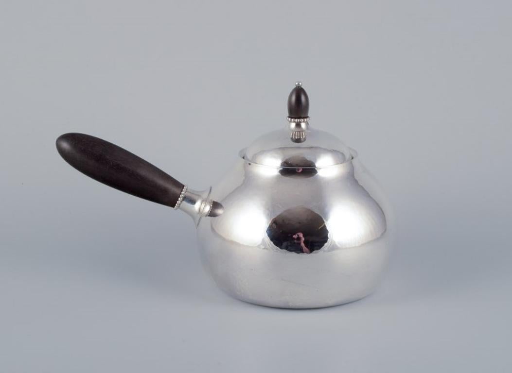Danish Georg Jensen teapot in sterling silver with an ebony handle and lid knob.  For Sale