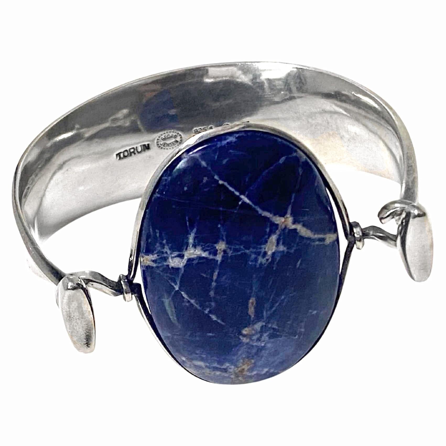 Georg Jensen Bangle with Sodalite model # 203 Designed by Vivianna Torun Bülow-Hübe C.1969. Fits most wrists up to 6.5 - 7.0 inches, tension clamp opening. Cabochon polished sodalite gauges approximately: 4.50 x 3.00 cm. Stamped with: Georg Jensen