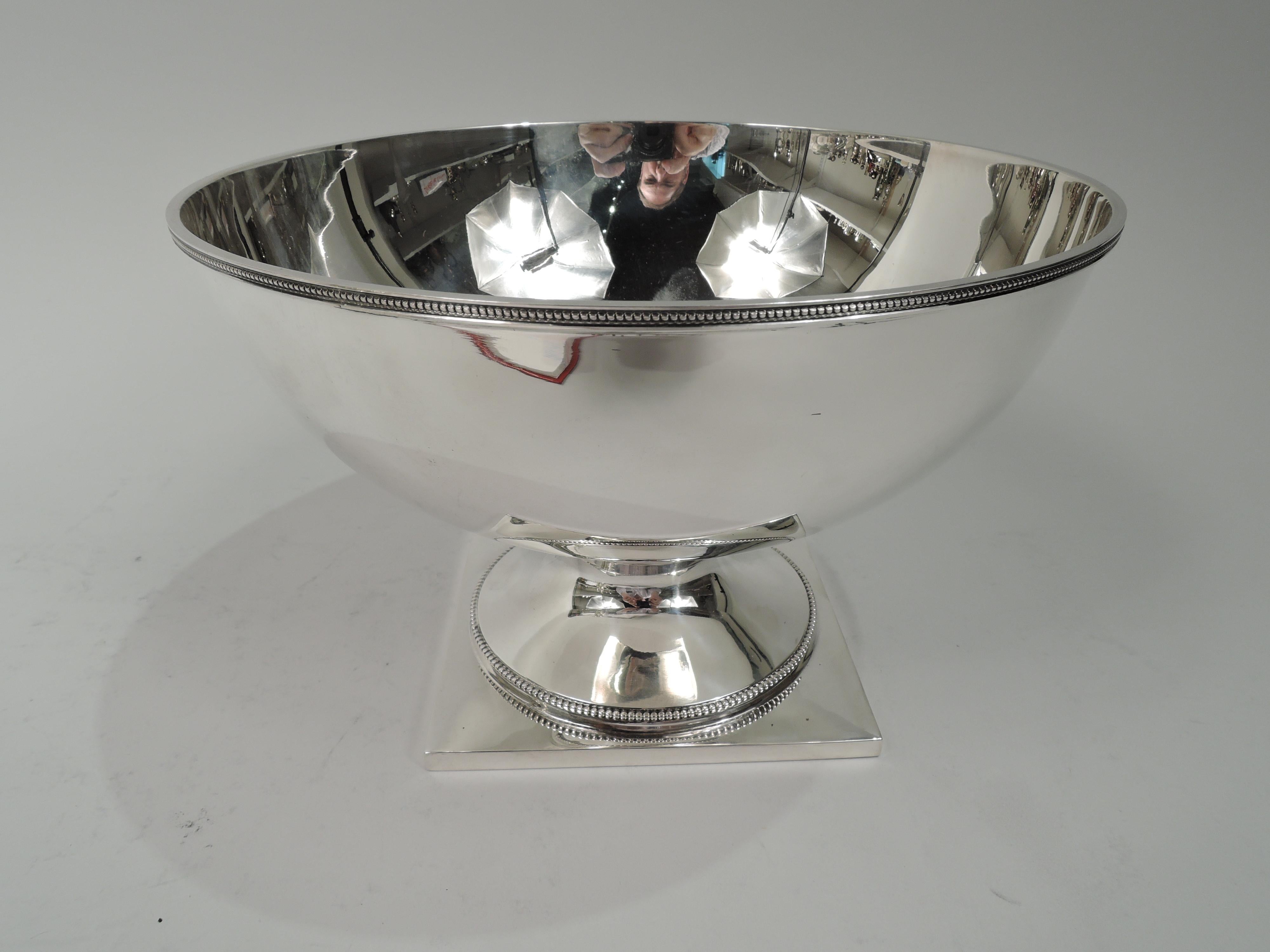American Neoclassical sterling silver bowl. Retailed by Georg Jensen USA in New York. Curved sides and raised round foot mounted to square base. Beading. Fully marked including retailer’s stamp, no. 777, and phrase “Reproduction”. Weight: 20 troy