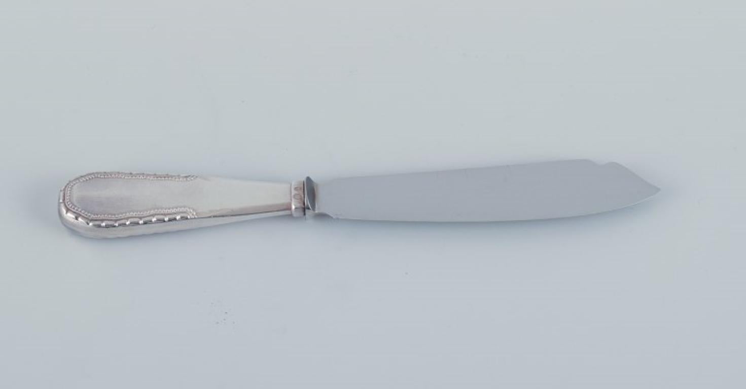 Couteau à gâteau Viking de Georg Jensen en argent 830. 
Lame en acier inoxydable.
Poinçon de 1915-1932.
En parfait état.
Dimensions : I.L.A. 21.9 cm