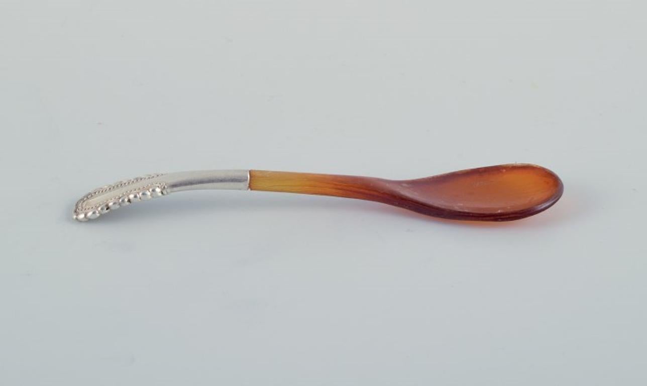 Georg Jensen, Viking, rare salt spoon with amber-coloured horn handle. 
Sterling silver.
Stamped GJ 1915.
In excellent condition.
Dimensions: L 10.6 cm.