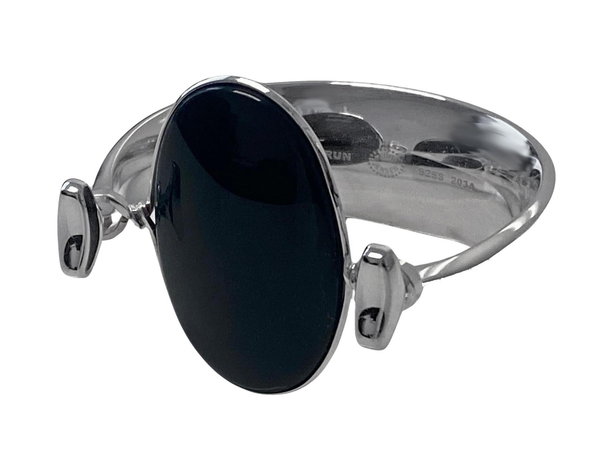 Georg Jensen Bangle with black onyx model # 203A Designed by Vivianna Torun Bülow-Hübe C.1969. Fits most wrists up to 6.5 inches, tension clamp opening. Cabochon polished onyx gauges approximately: 4.50 x 3.00 cm. Stamped with: Georg Jensen (oval