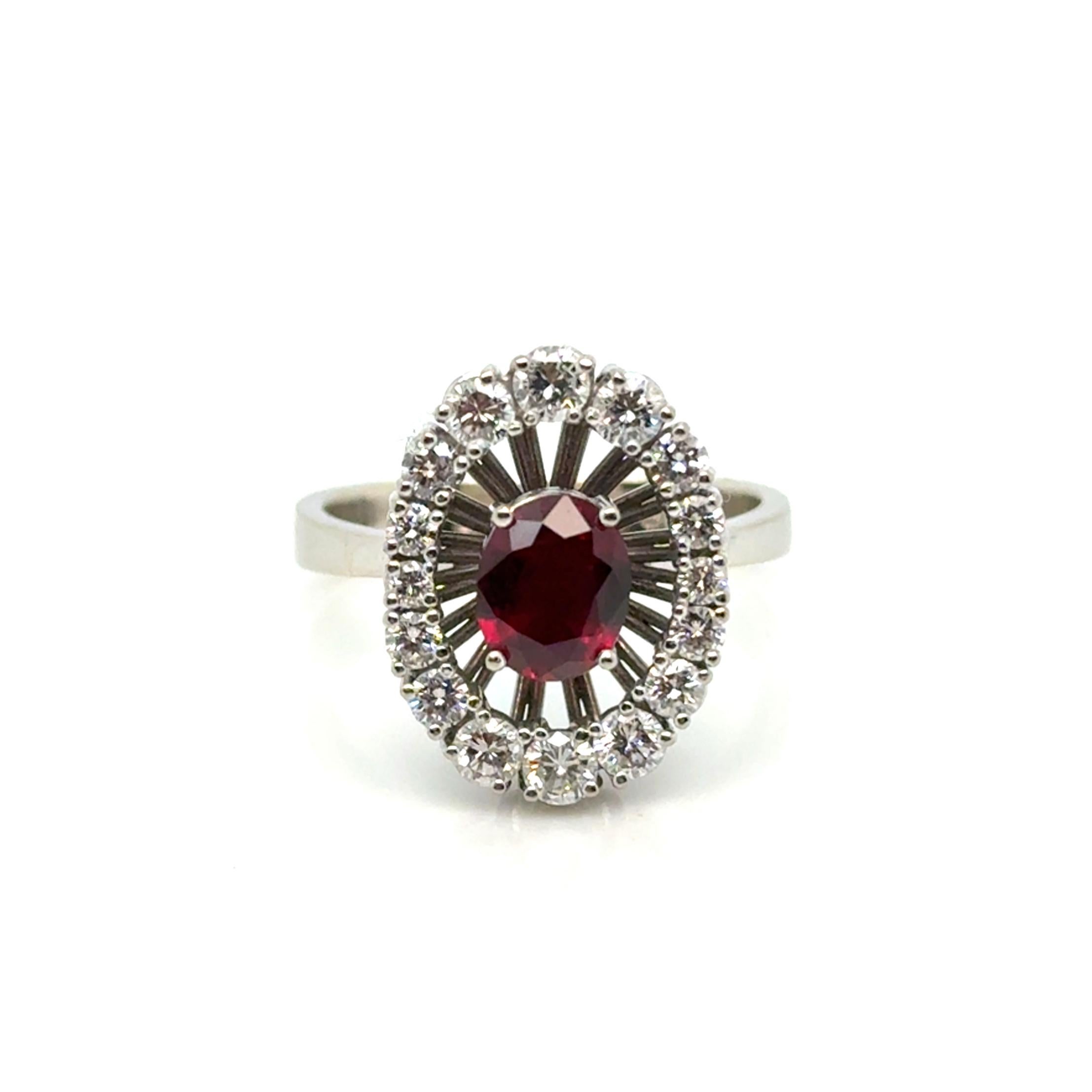 18K Gold ring by Georg Jensen & Wendel, set with a faceted oval vivid red ruby, approximately 7.0 x 5.8 mm. Additionally adorned with brilliant-cut diamonds, totaling approximately 0.75 carats. Stamped GJ&W. Also features an engraving from a