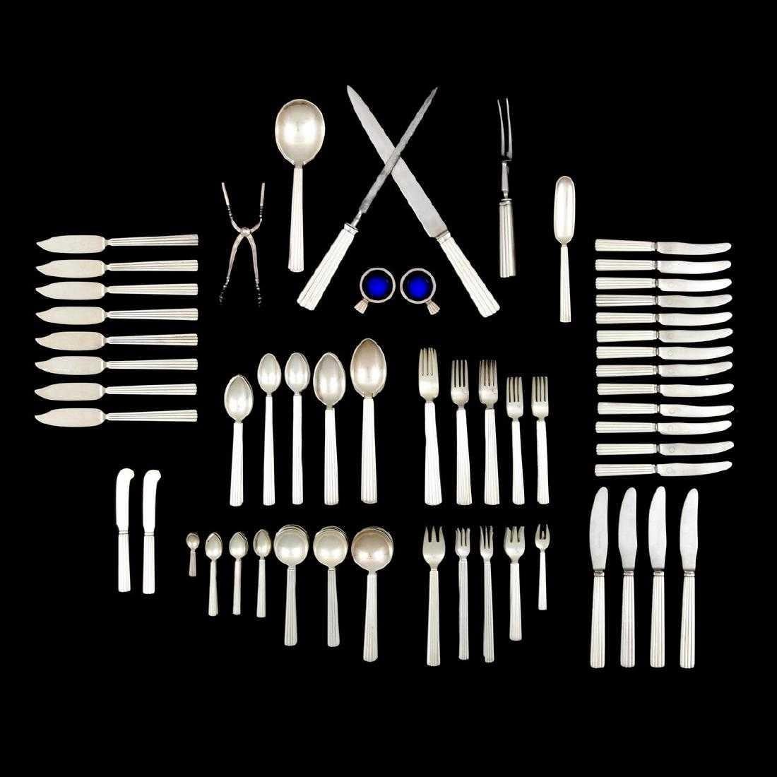 Bernadotte flatware set by Sigvard Bernadotte for Georg Jensen. Service in the Bernadotte pattern is comprised of four dinner forks, four dinner knives, eight luncheon forks, four teaspoons, twelve demitasse spoons, two butter knives, two fish