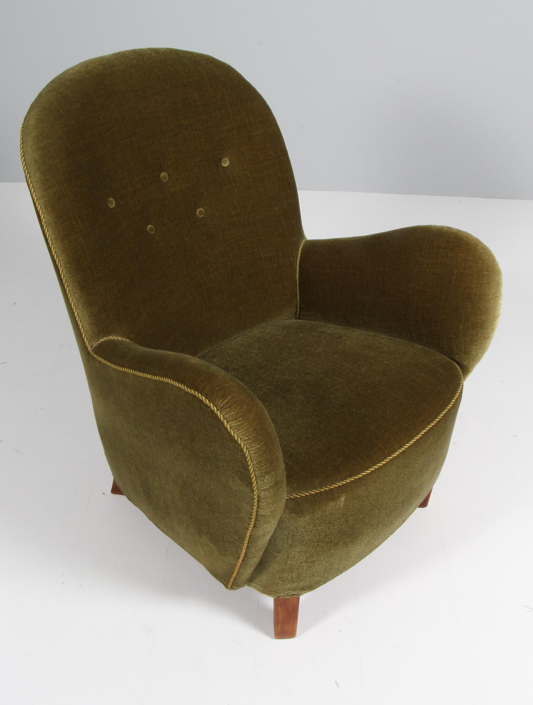 Georg Kofoed lounge chair in original velvet with buttons.

Legs of stained beech.

Made by Georg Kofoed in the 1940s.