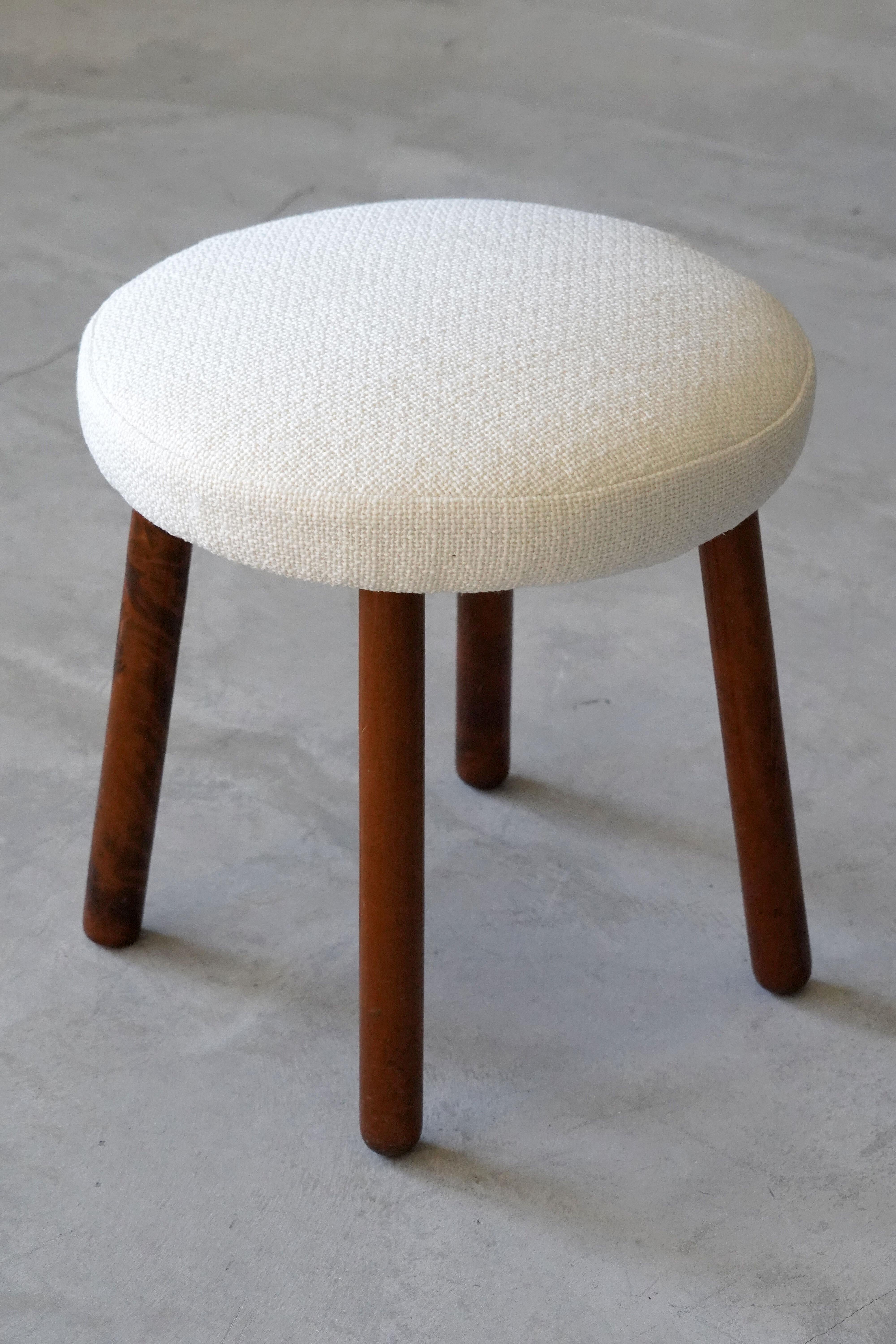 A stool, produced by Georg Kofoed. With dark-stained wooden legs. Reupholstered in brand new white fabric. 

Other designers of the period include Philip Arctander, Arnold Madsen, Josef Frank, Viggo Boesen and Jean Royere.