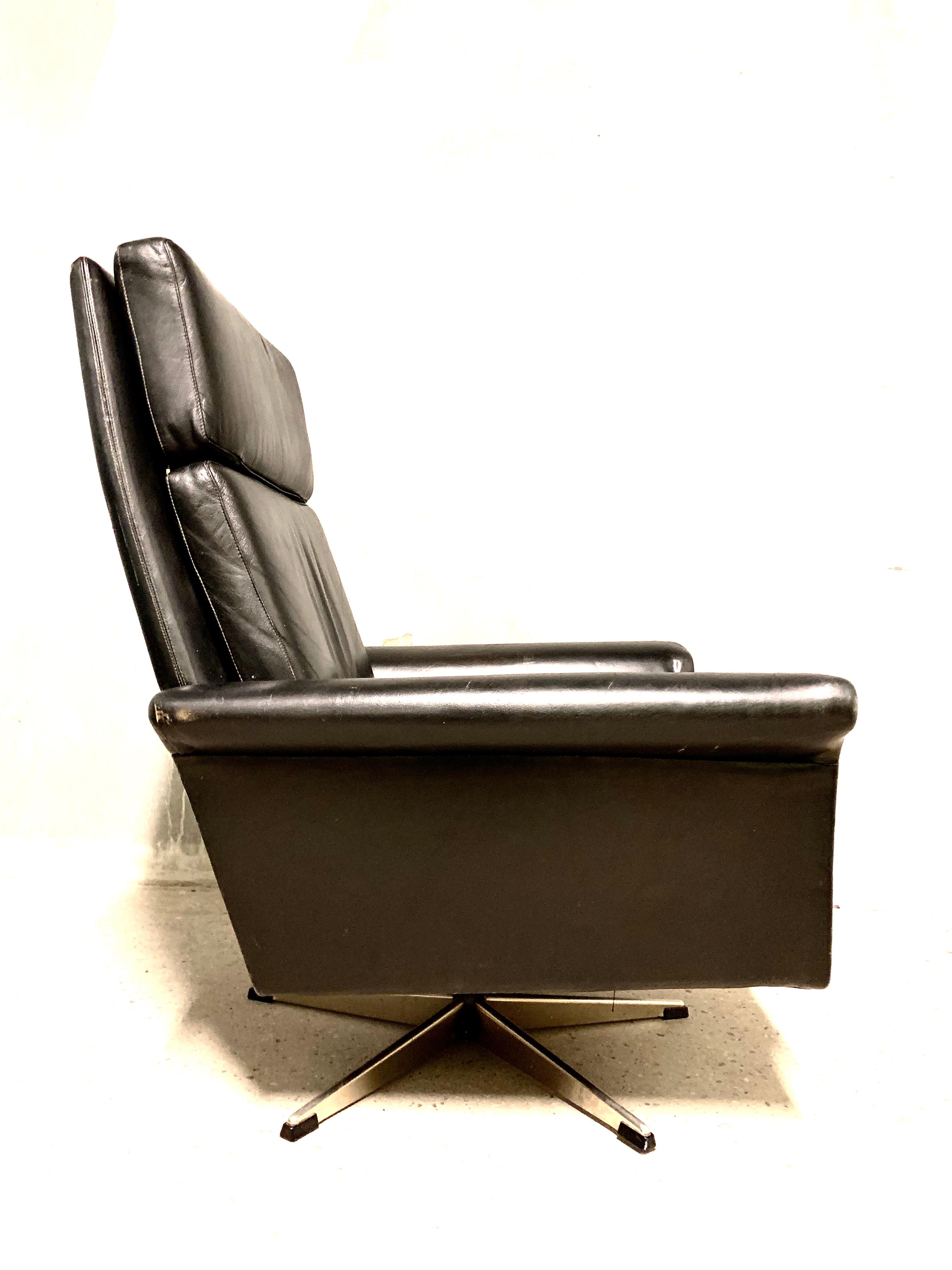 Beautiful modern swivel chair in black colored leather on a chrome-plated aluminum-plated swivel base. The chair is in good vintage condition with lovely patina. Designed by Georg Thams and executed by Vejen Polstermøbelfabrik.
  
