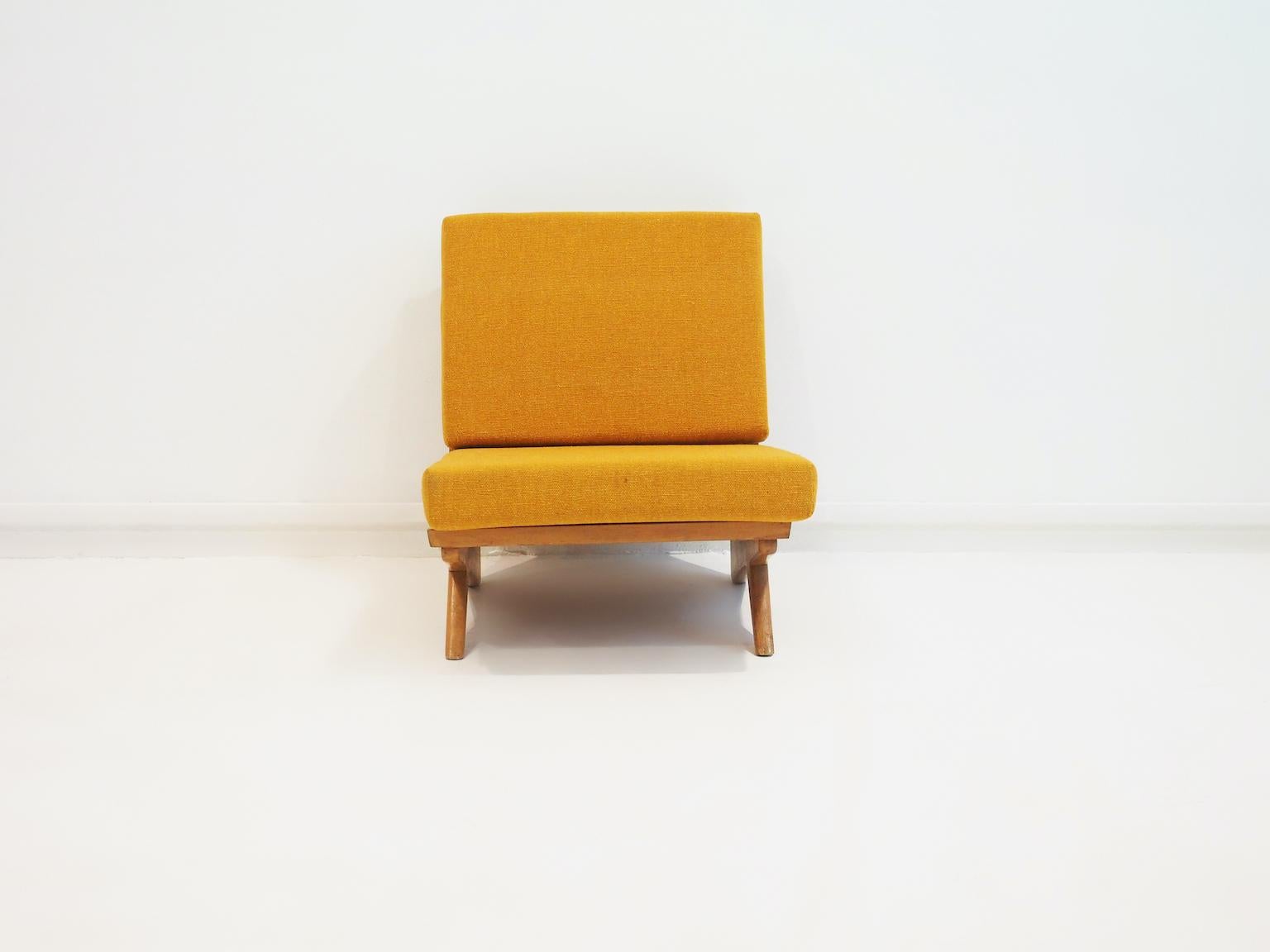Minimalist Danish lounge chair with beech wood frame designed by Georg Thams in the 1970s. Loose seat and back cushions covered with yellow/mustard colored wool fabric.
