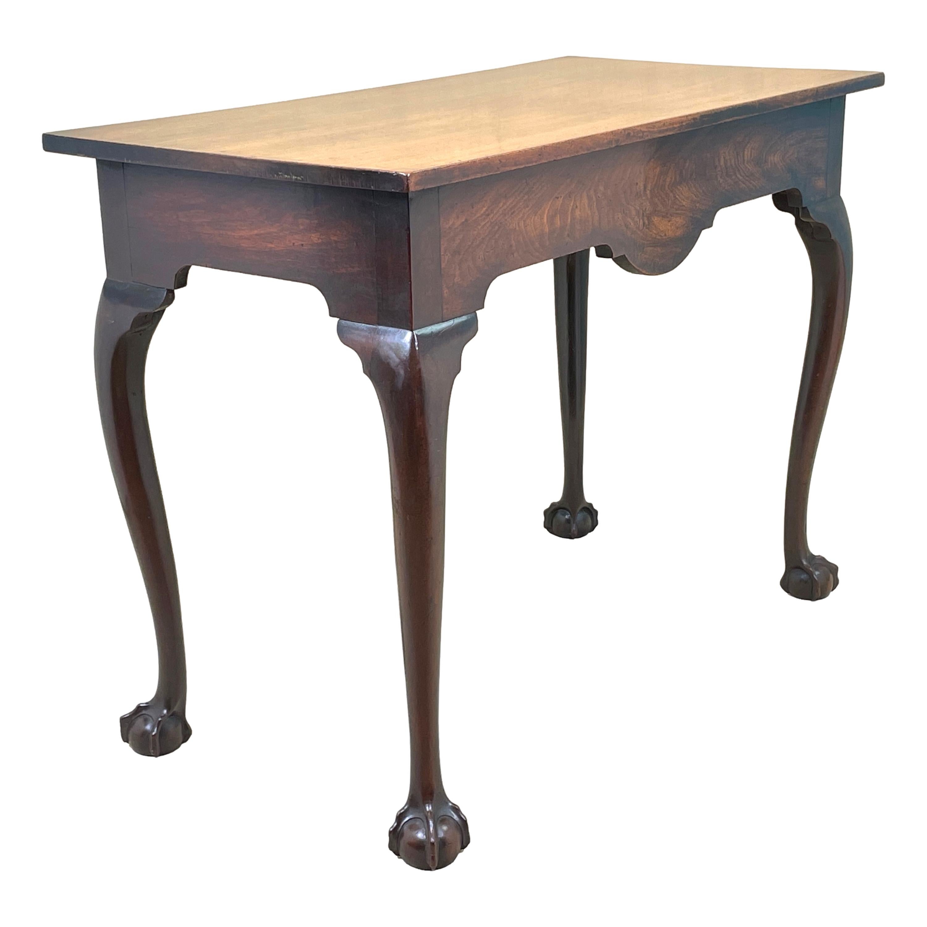 An extremely rare early 18th century, George 1 period mahogany serving table of exceptional untouched colour and patina, having well figured rectangular top over superbly figured, shaped frieze raised on four elegant, bold, cabriole legs terminating