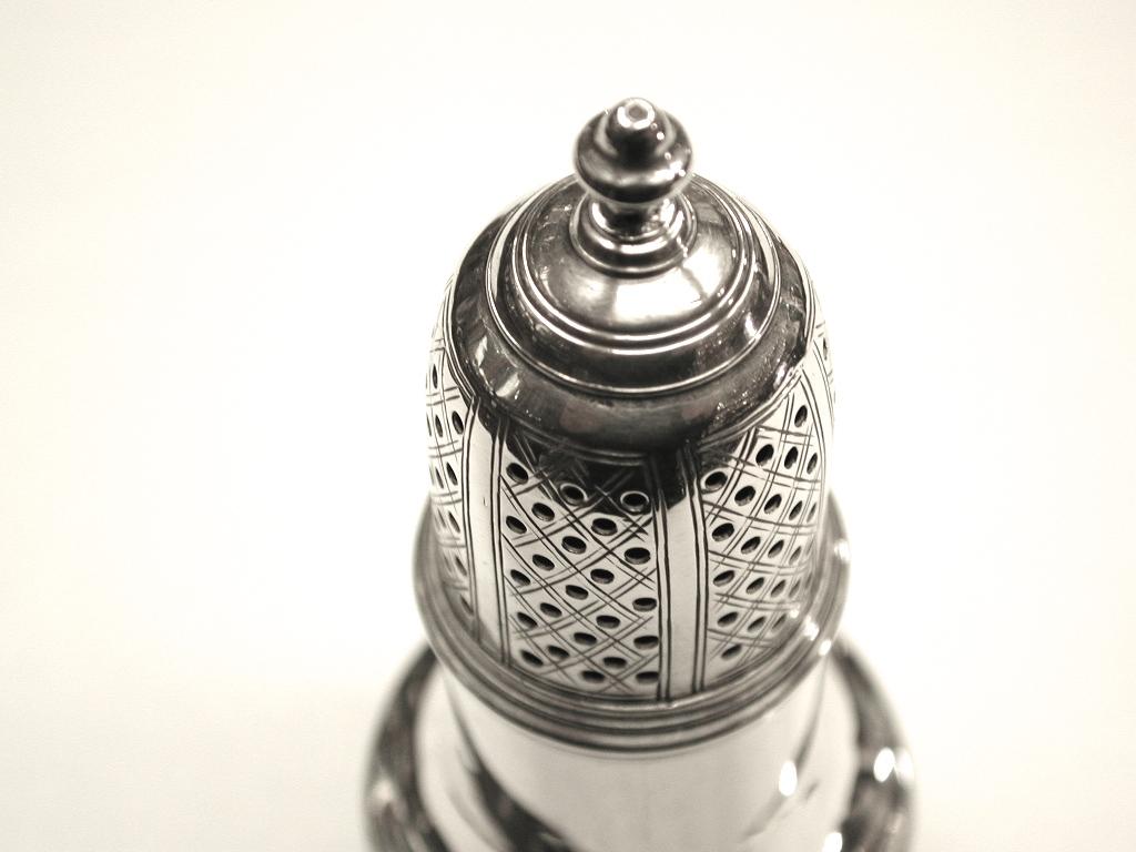 George 11 silver pepper pot dated 1748, Sam Wood, Assayed in London.
Classic shape for the period, with cross hatch engraving on the top with round holes
of a symmetrical pattern, with Sam Wood's makers mark and lion mark on the side.
The maker