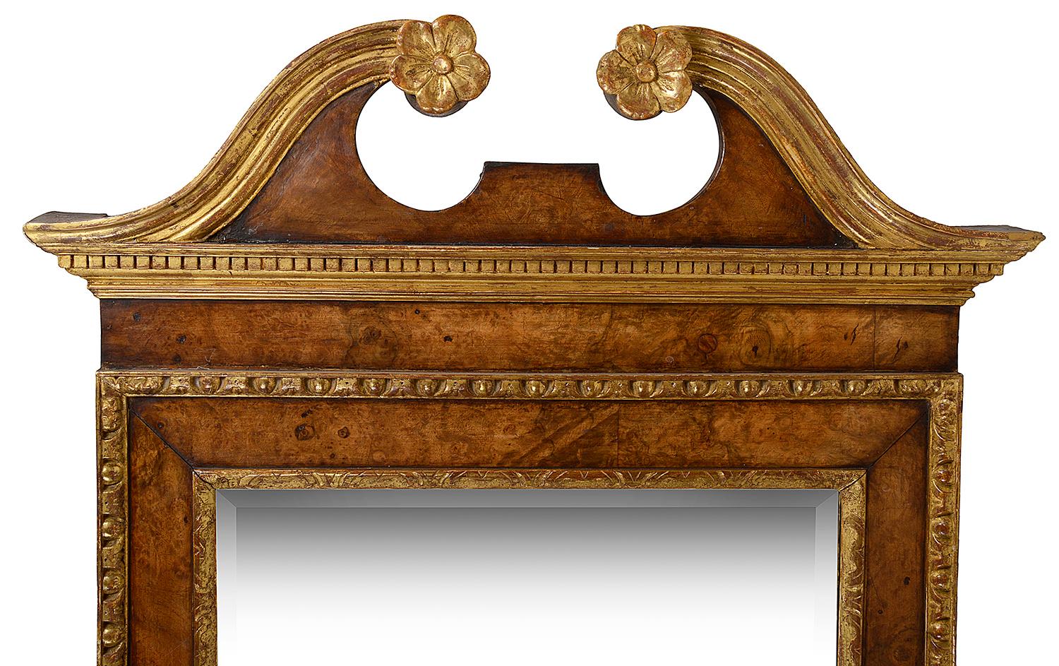 A good quality George 11, 18th century style walnut and parcel-gilt pier glass wall mirror, having carved swan neck pediment, burr walnut veneers, and carved fruit and leaf decoration to the base. Measures: 150cm (59