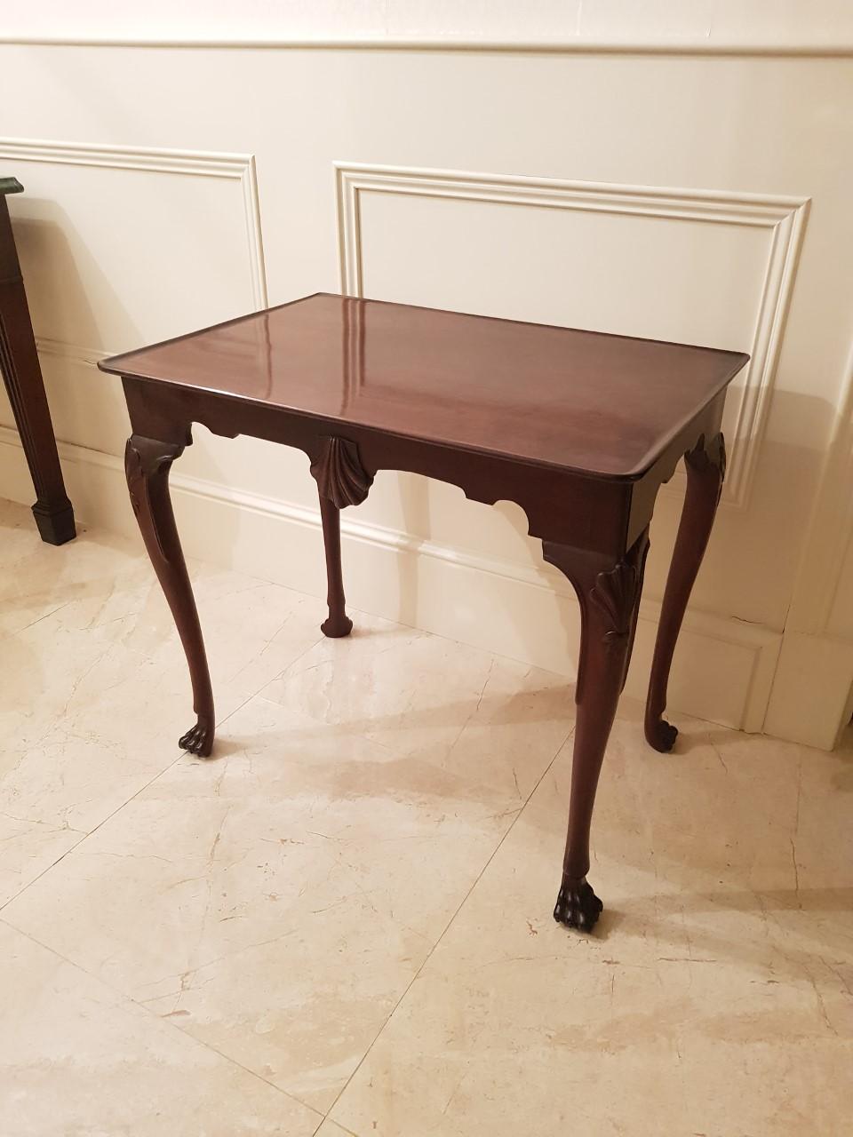 A fine mahogany silver table with centre carved shell and legs, terminating in lions paw feet, circa 1760.