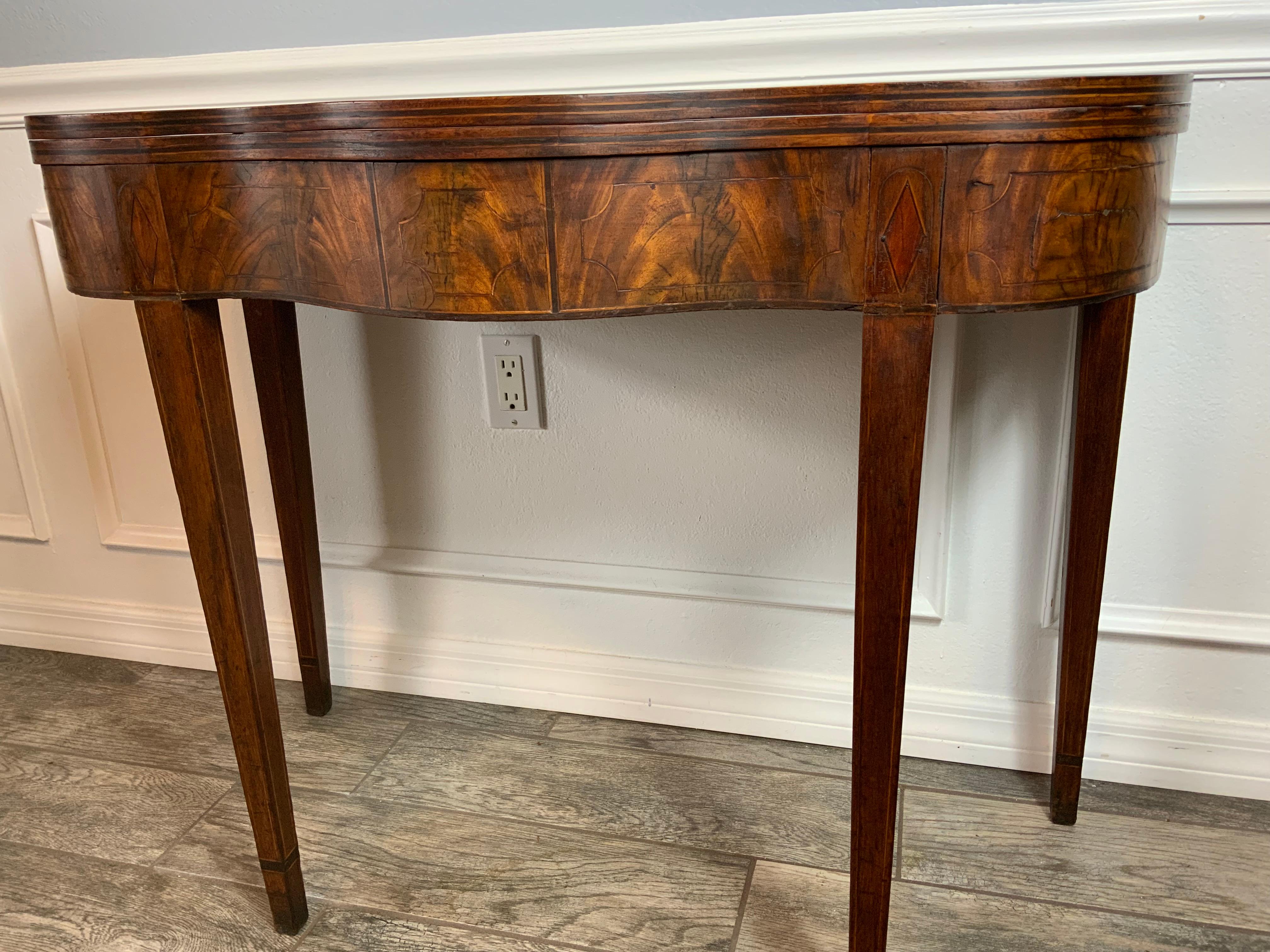 A very good quality Hepplewhite 18th century Mahogany card table. Several inlay patterns  across the frieze and double string inlay on the edges of the solid Mahogany tops.  Very good condition with an original dry surface with an exceptional color