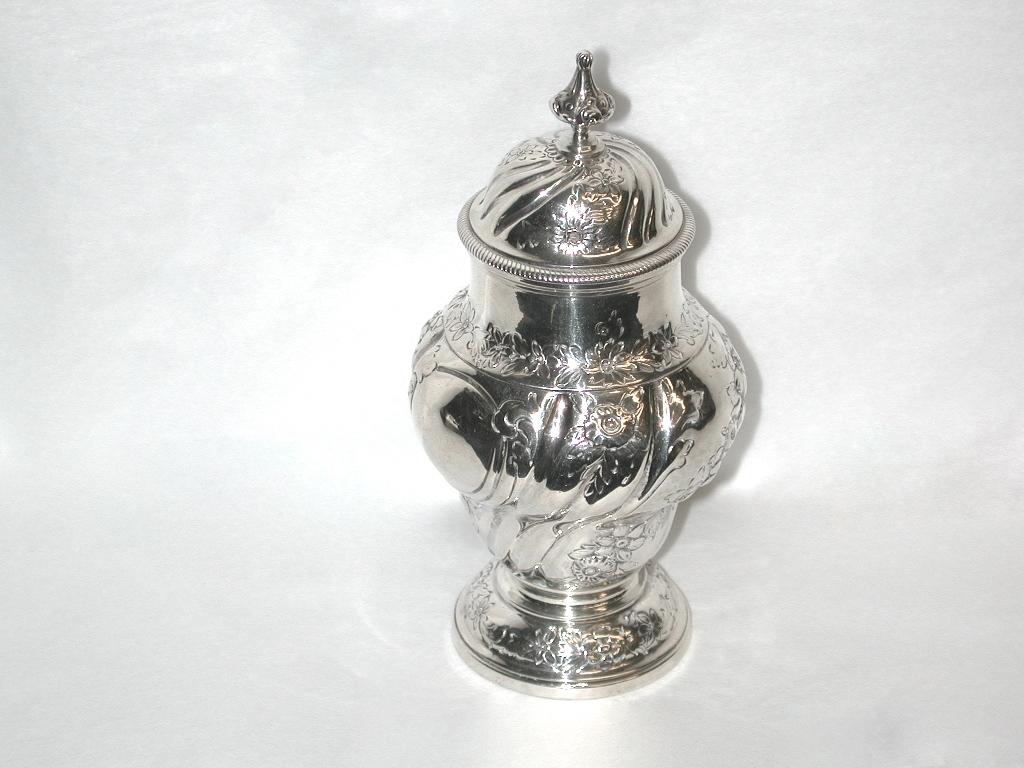 George 111 silver tea caddy, dated 1765, London, Benjamin Mountigue.
Very pretty hand chased tea caddy, with a pull off top which has a lion passant mark and
can be used as a measure of tea into the teapot.
Lovely cast scroll finial on the