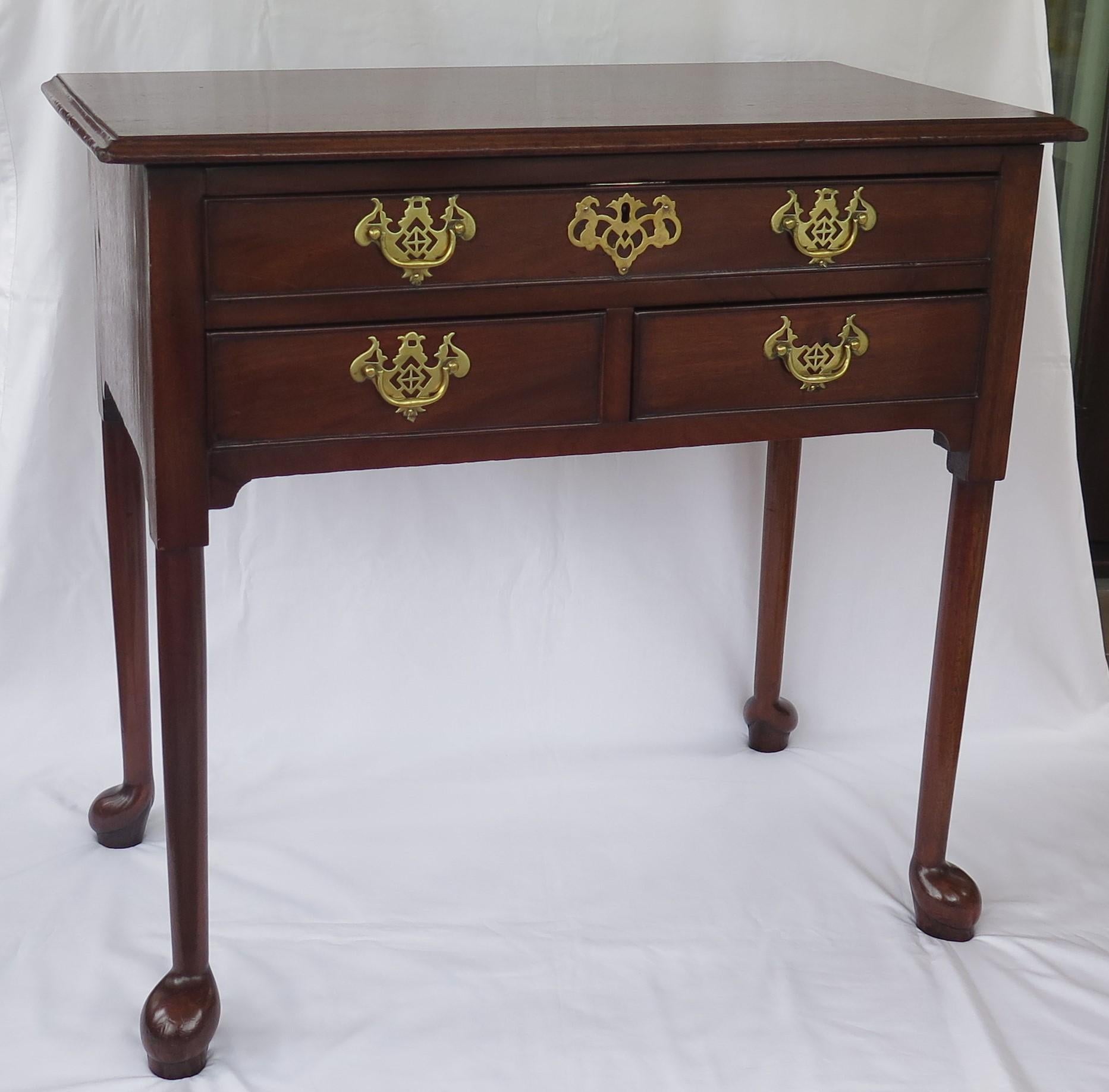 This is a fine quality, elegant lowboy side table dating to the English George II period, circa 1745.

This is a quality piece hand made out of a solid hardwood, possibly walnut. The one piece top is rectangular with a molded edge, raised on four