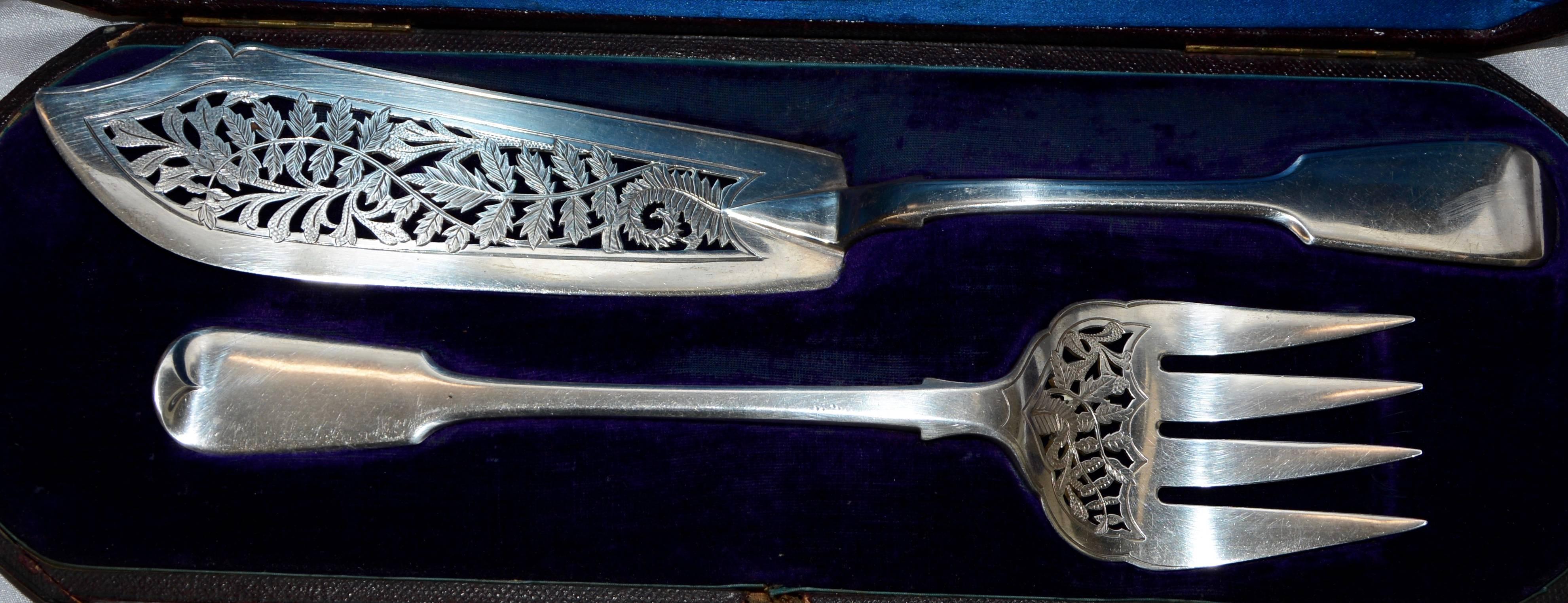 The engraving style on the cut-out of this lovely sterling silver fish set by the George Angell Co. of London are exquisite! Ferns and leaves are intertwined on each piece. The hallmarks identify the pieces as being made in London in 1875. They