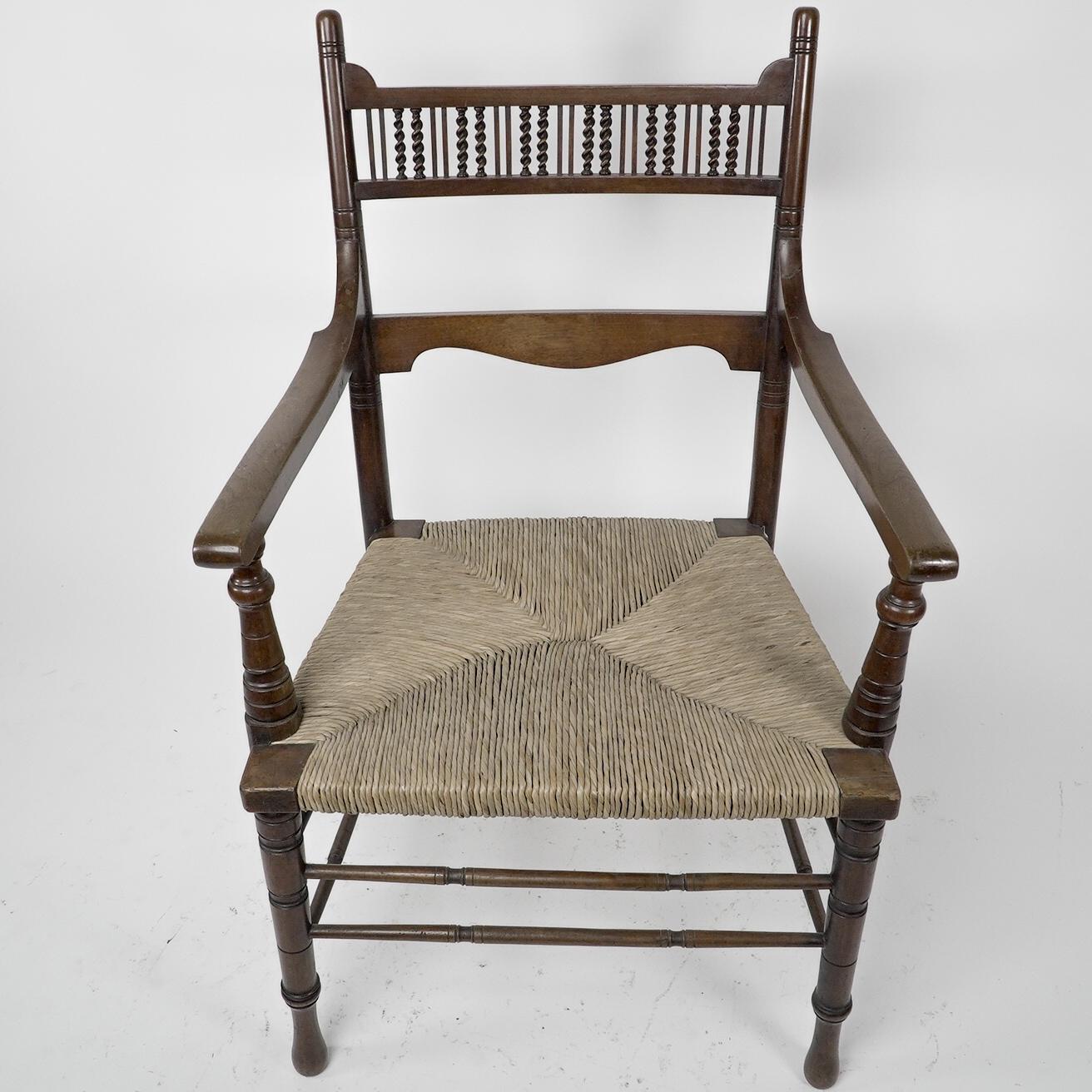 George Bell & George Freeth Roper. Probably made by Kendal Milne & Co for Herman Schill. An Aesthetic Movement Walnut armchair with a row of fine barley twist turnings to the upper back, and a shaped back rest below. The back legs curving back with