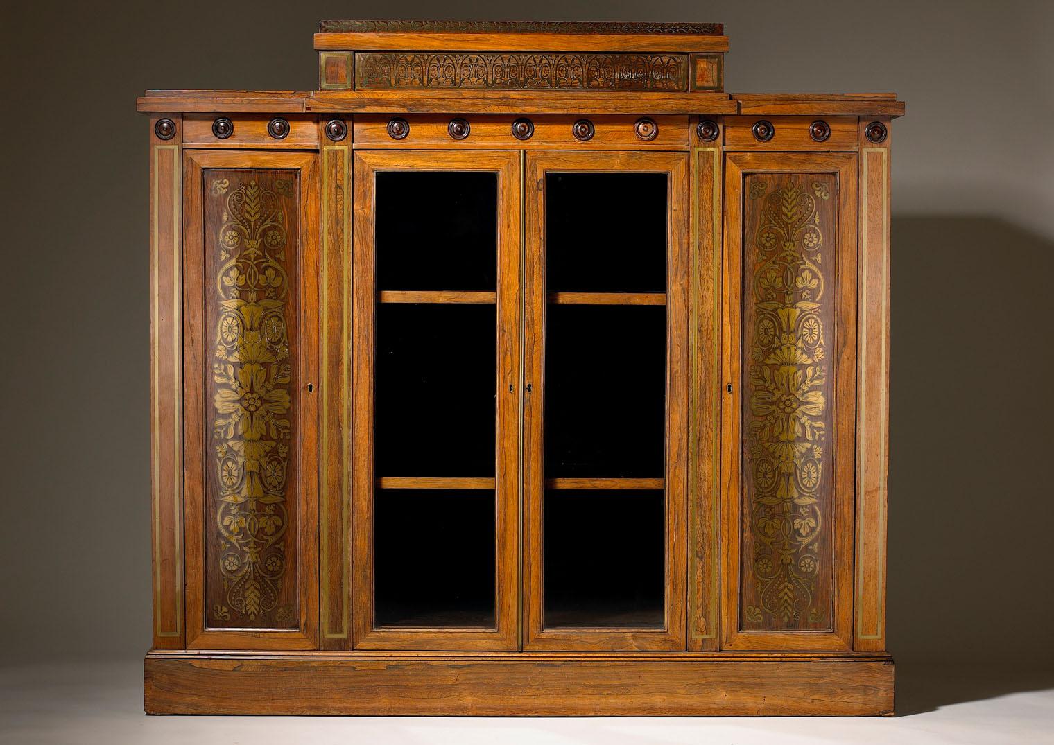 A fine early 19th-century Grecian revival side cabinet in the manner of George Bullock, two glazed central doors flanked by cupboards with inlaid marquetry panels of foliate floral detail the frieze above picked out with turned wooden roundels and a
