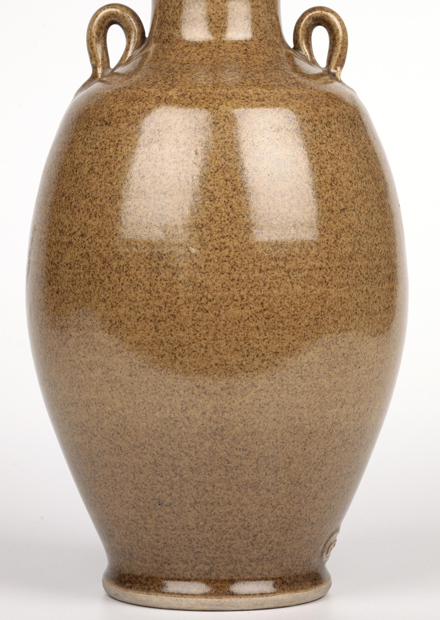 Un eccezionale vaso a due manici a forma di anfora realizzato a mano da George Cass e risalente al 1970 circa. Questo vaso in gres finemente lavorato poggia su un piede rotondo e stretto non smaltato ed è di forma bulbosa alta ed elegante, con