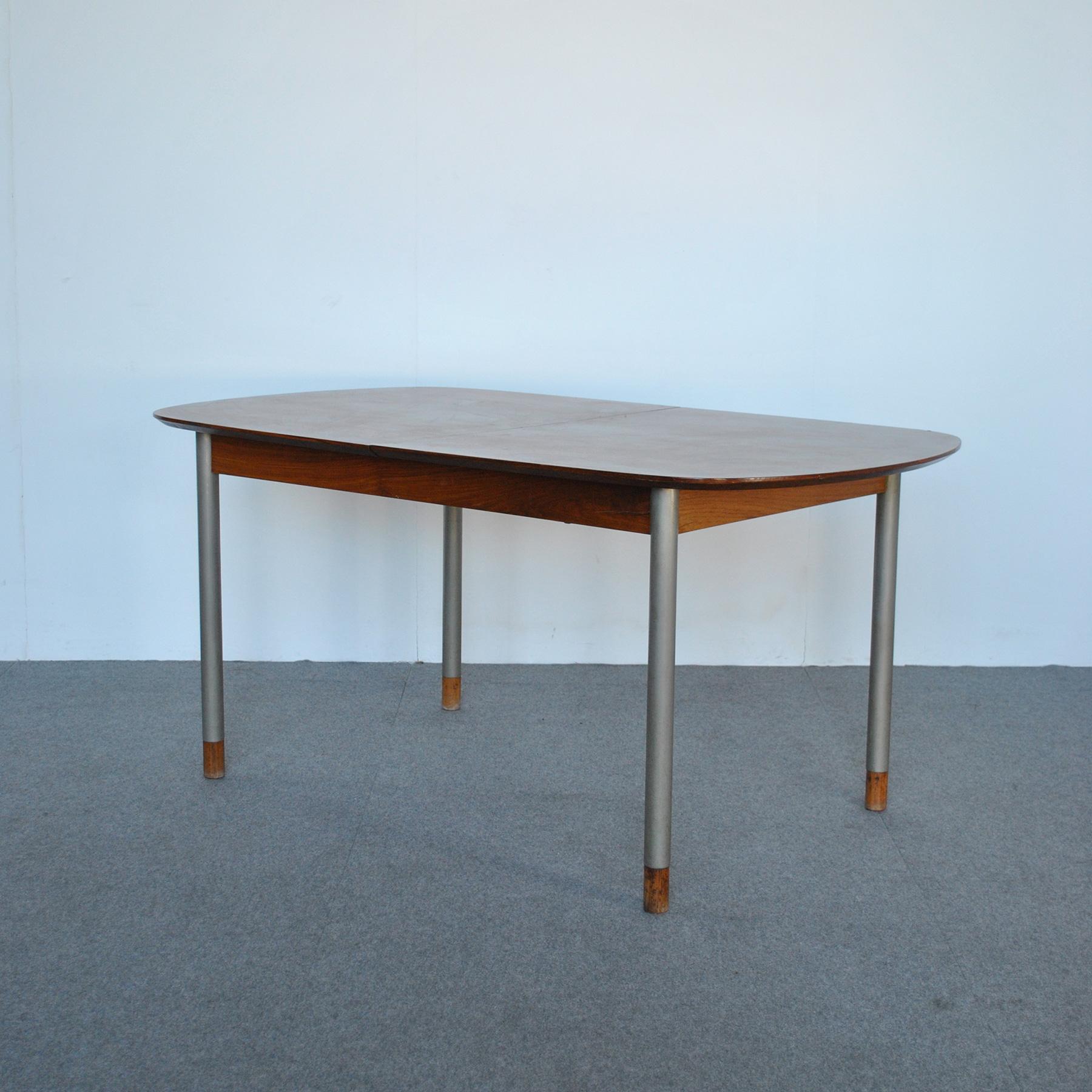 Table avec plateau en bois ouvrable et pieds en métal avec extrémités en bois, design George Coslin, production des années 1960. 
La table ouverte a une longueur maximale de 215 cm.