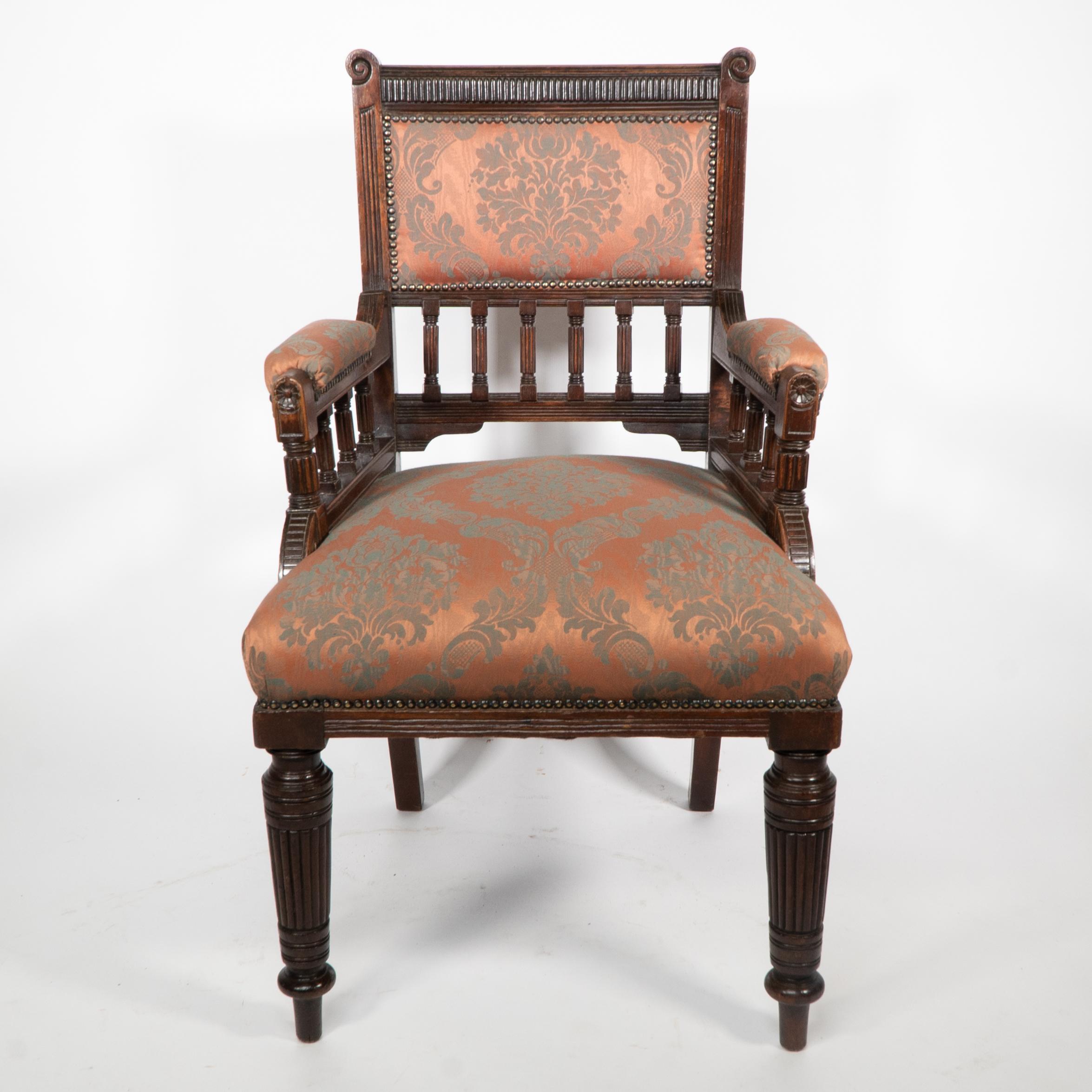 George Faulkner Armitage (attribuito). Poltrona in mogano dell'Aesthetic Movement con dettagli a coste sul poggiatesta affiancati da terminali intagliati a volute. Con decorazioni a tramaglio su tutta la superficie e supporti torniti e scanalati