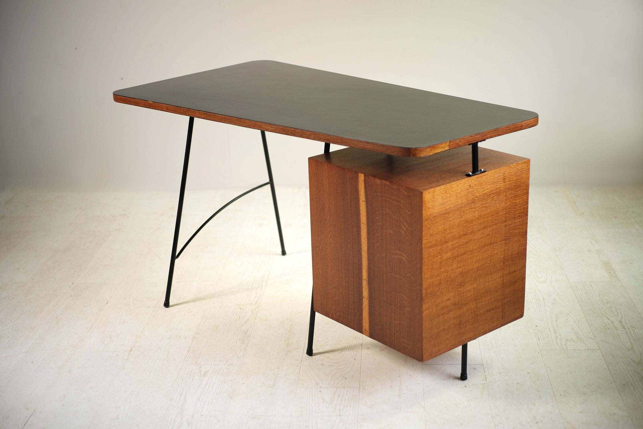 Georges Frydman, desk in oak, Formica and tubular metal, edited by EFA, France, 1956. The asymmetrical top is dressed in a black Formica on the upper side, a shaded white Formica on the underside. The box has three drawers, one of which has a