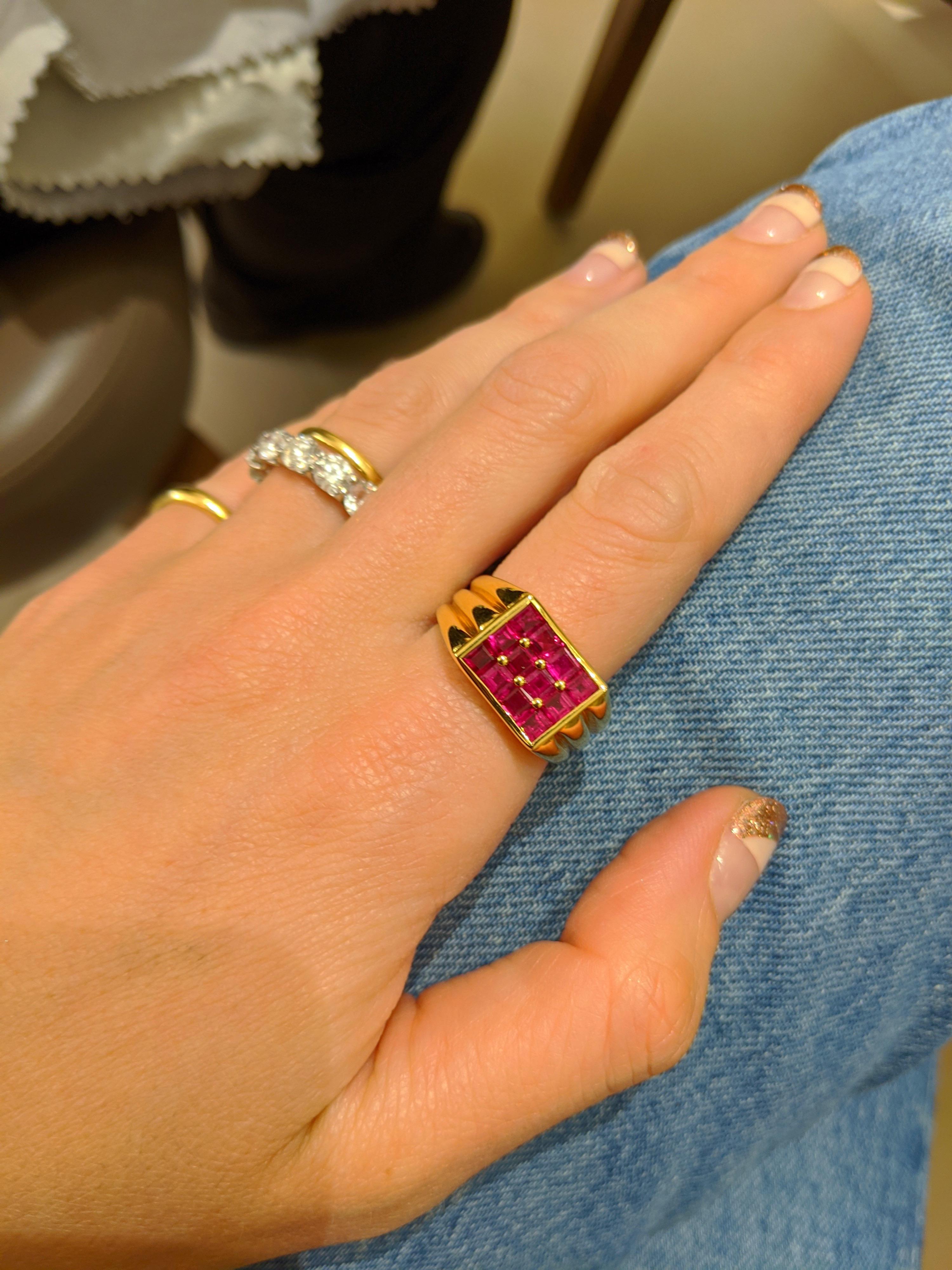 Designed by George Gero, this 18kt yellow gold  gents ring is set with 12 square cut Rubies in a concave cloute (small gold beads) setting. The shank has 3 ribbed sections that go all the way around.
Ring size 10   Sizing options may be