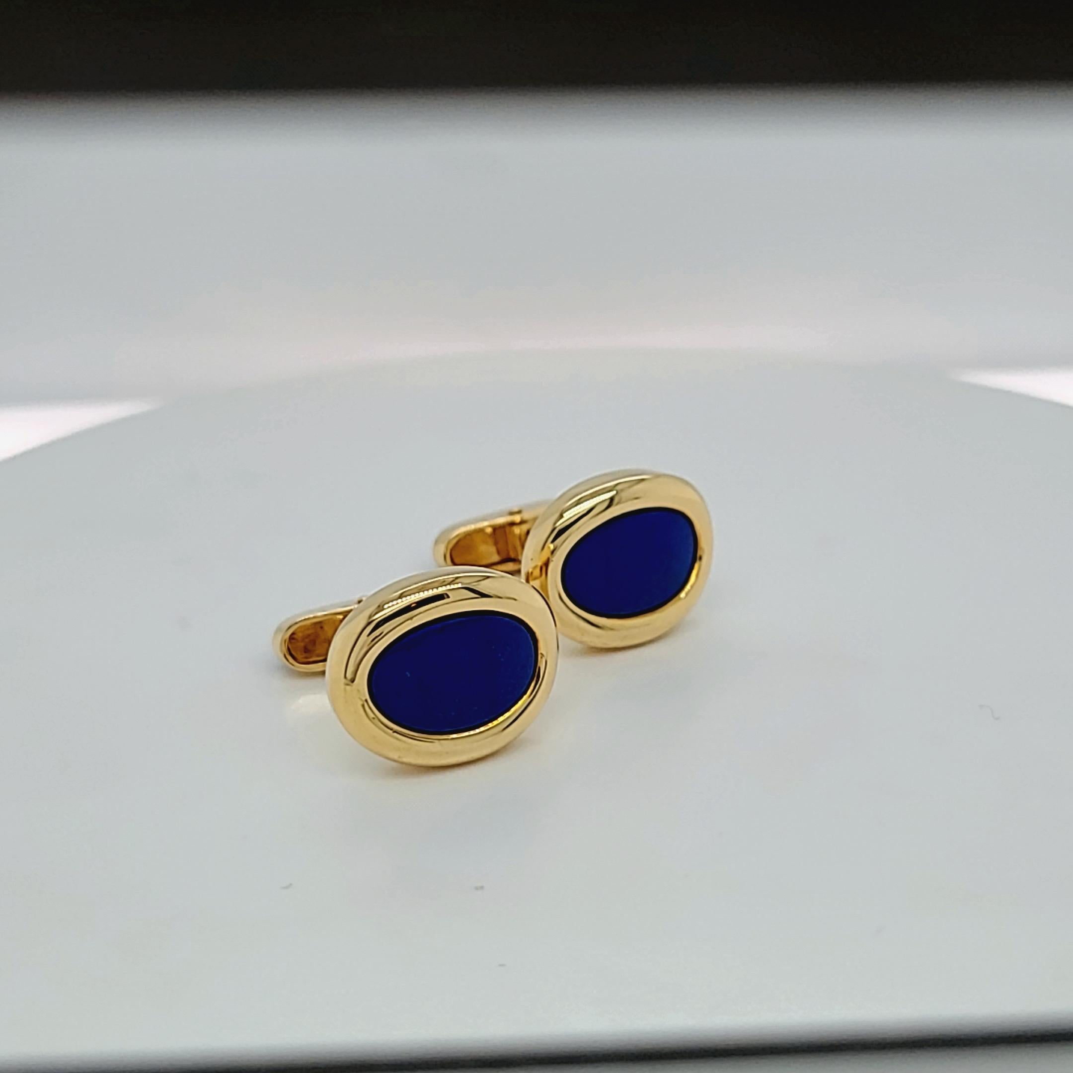 Classic and traditional ,these oval cuff links are timeless. The oval shaped cuff links with Lapis and Black Onyx centers are set in polished 18 karat. yellow gold. The blue and black colors of the stones make these cuff links extremely wearable.