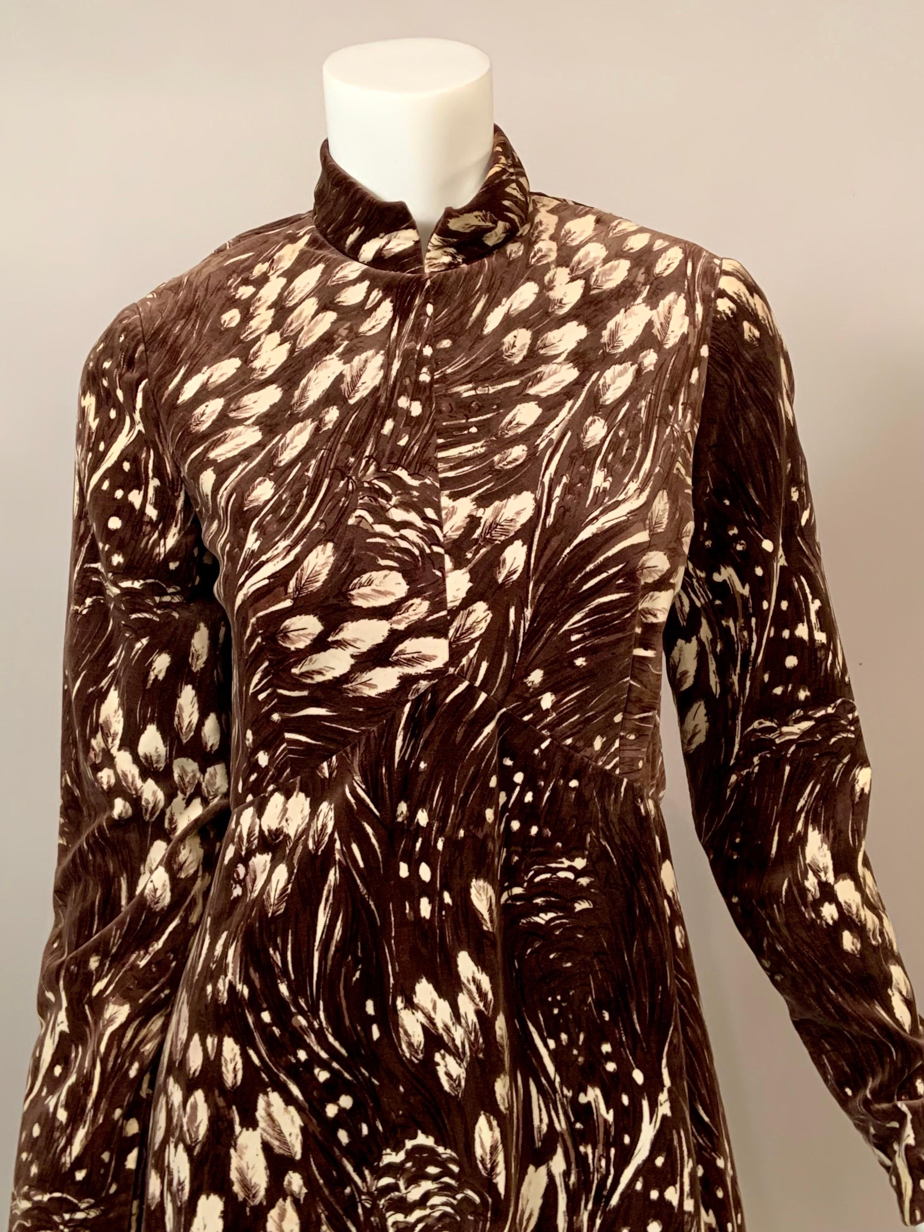 New York Designer George Halley used a lovely cotton velvet with an ombré mocha colored background and a creamy beige feather print for this 1970's evening dress.
The dress has a high collar, a waistline which rises to a point at the center front