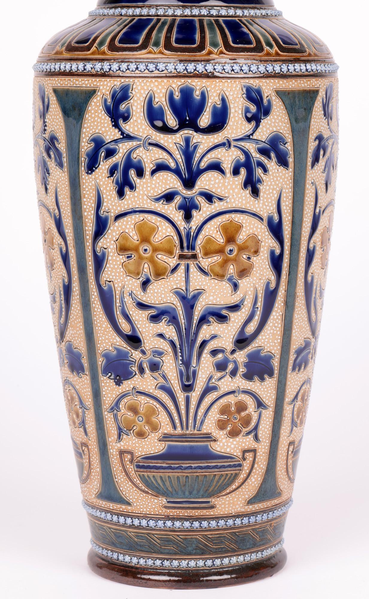 A large, impressive and rare aesthetic movement Doulton Lambeth vase by renowned artists George Hugo Tabor, Eliza L Hubert and Ernest R. Bishop whose work is rare and dated 1883. The tall stoneware vase stands on a narrow round foot with a tall