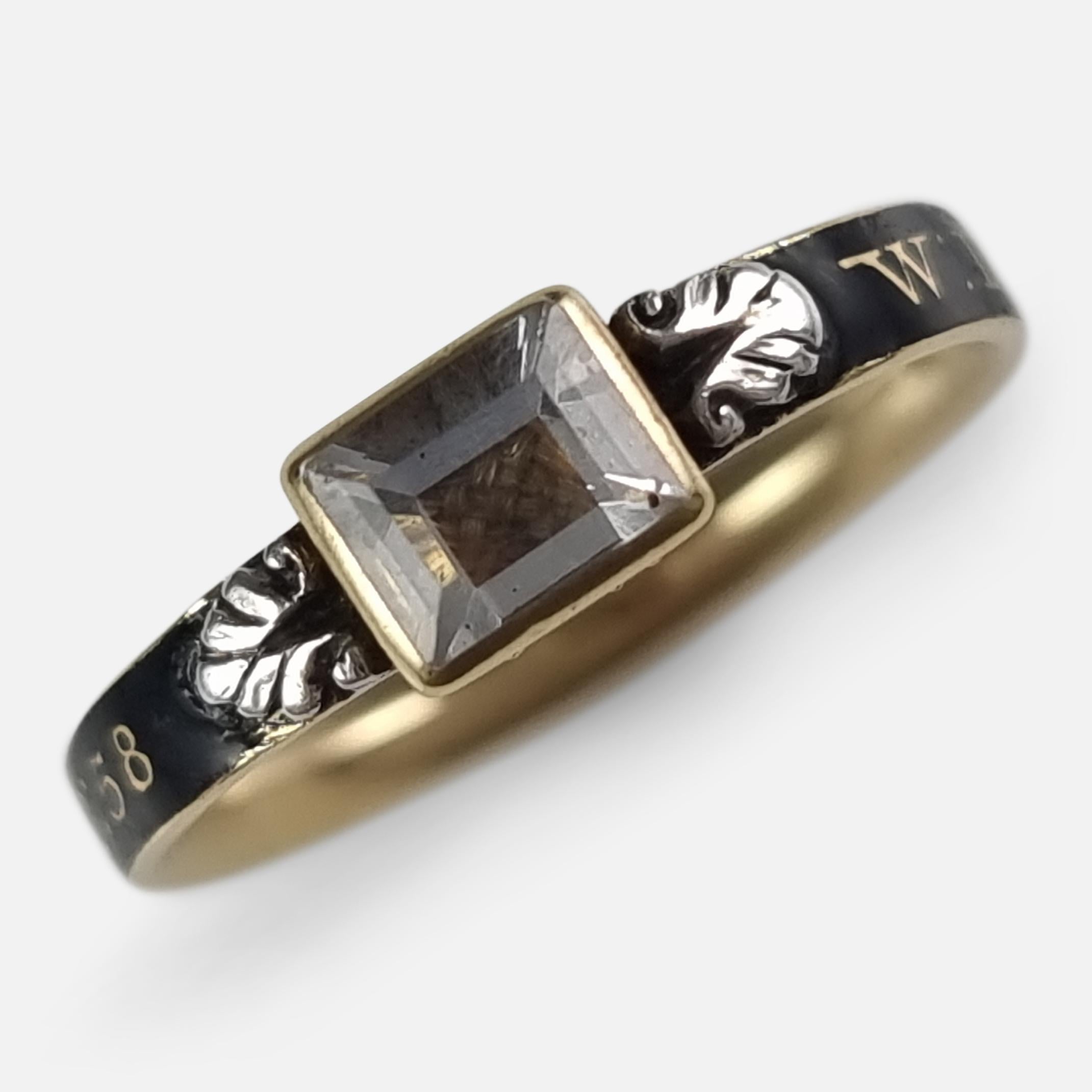 A George I 18ct yellow gold, rock crystal, hair-work, and black enamel mourning ring. The gold ring bears the inscription 