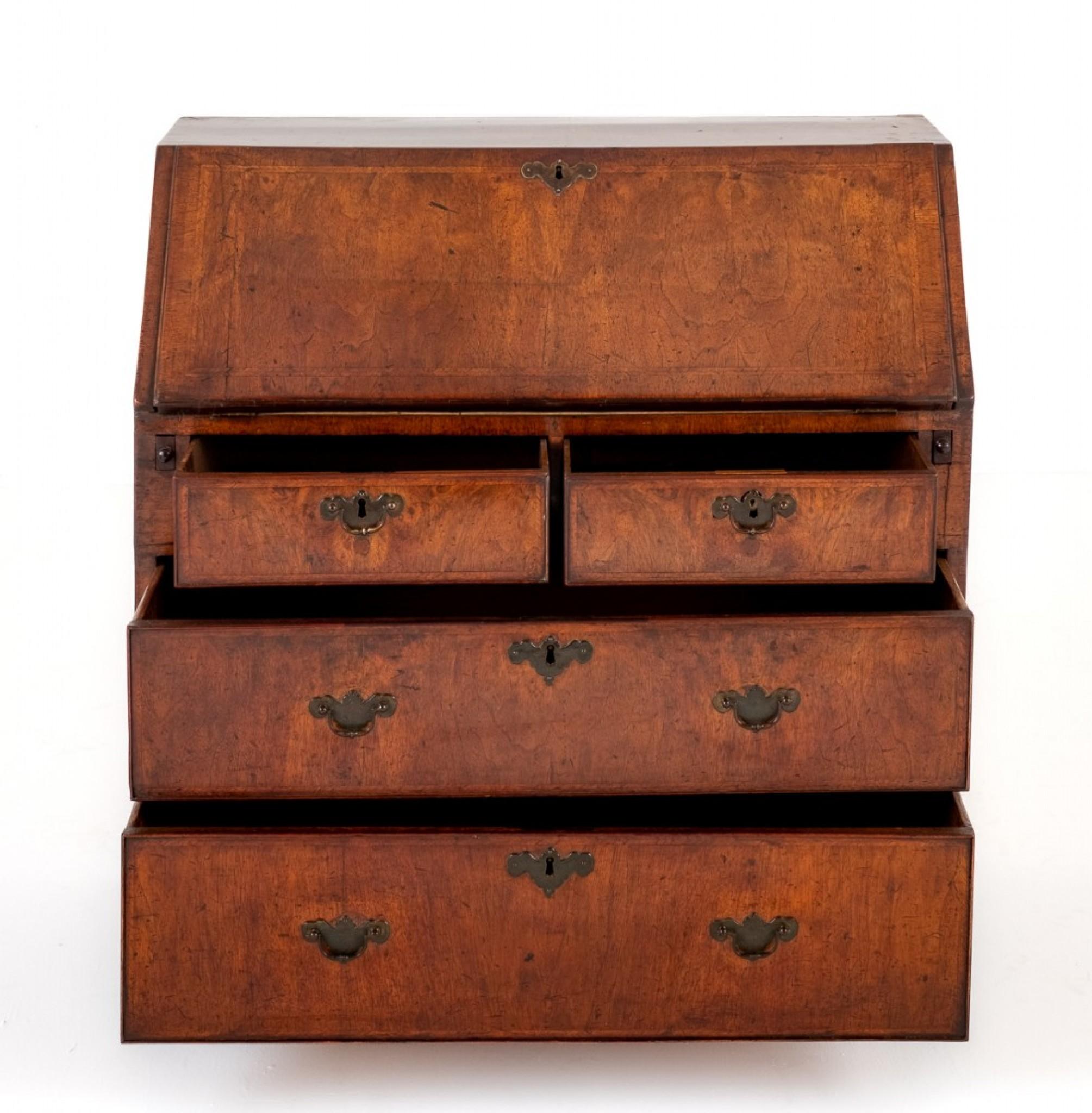 George I Walnut Bureau.
This Bureau Stands Upon Bracket Feet and Features an Arrangement of 2 Over 2 Oak Lined Drawers.
18th Century
The Drawers and the Fall Having Herringbone Inlays.
The Interior Having an Assortment of Drawers and