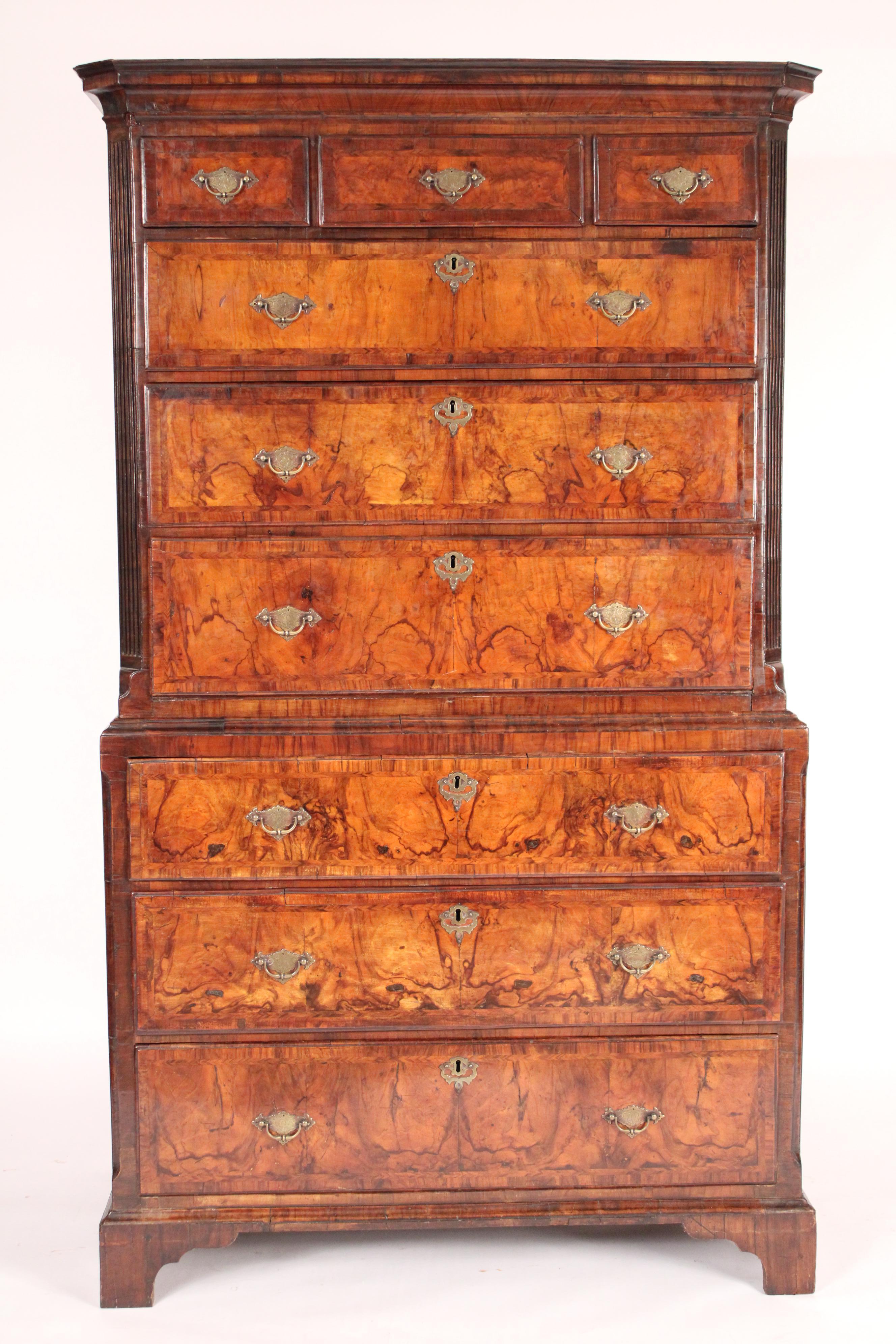 George I Burl walnut and walnut chest on chest, 1st half of the 18th century. The upper section with a cove pediment 3 upper drawers and 3 graduated drawers flanked by fluted sides, the lower section with 3 graduated drawers with brass hardware,