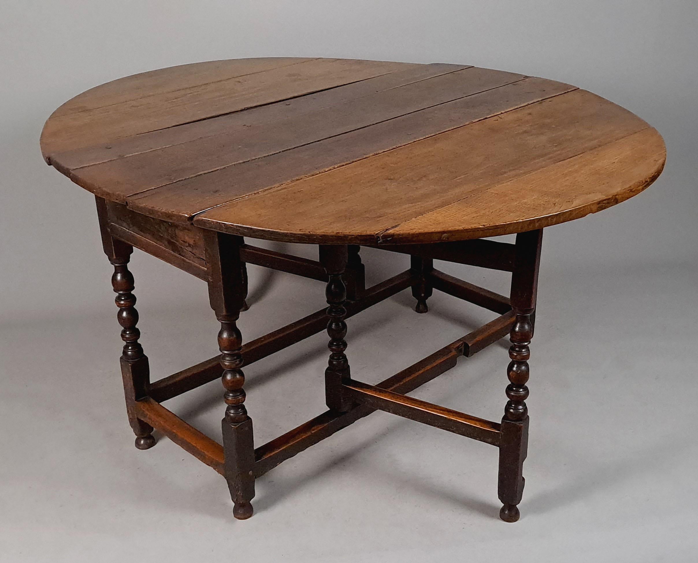 A very heavy and original George I oak drop leaf oval table with a good dark straw colour and rich natural patina dating from c. 1720.
Peg jointed throughout with two gate legs which open outwards from the main frame to support each leaf.

The top