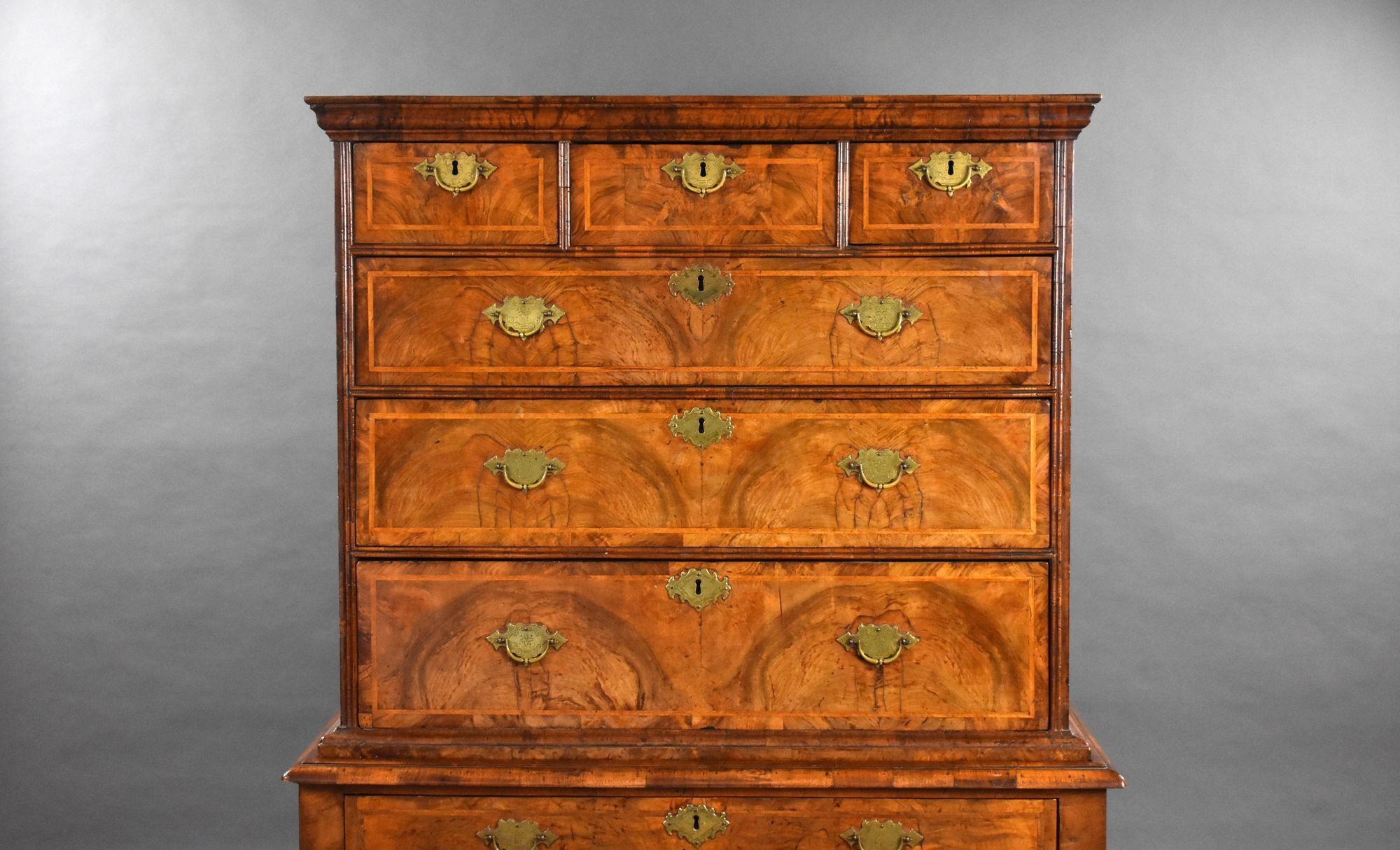 For sale is a good quality George I figured walnut chest on stand, having walnut and feather banded drawers, each with brass handles, having three short over two long drawers in the top, with a long drawer below in the base, above barley twist
