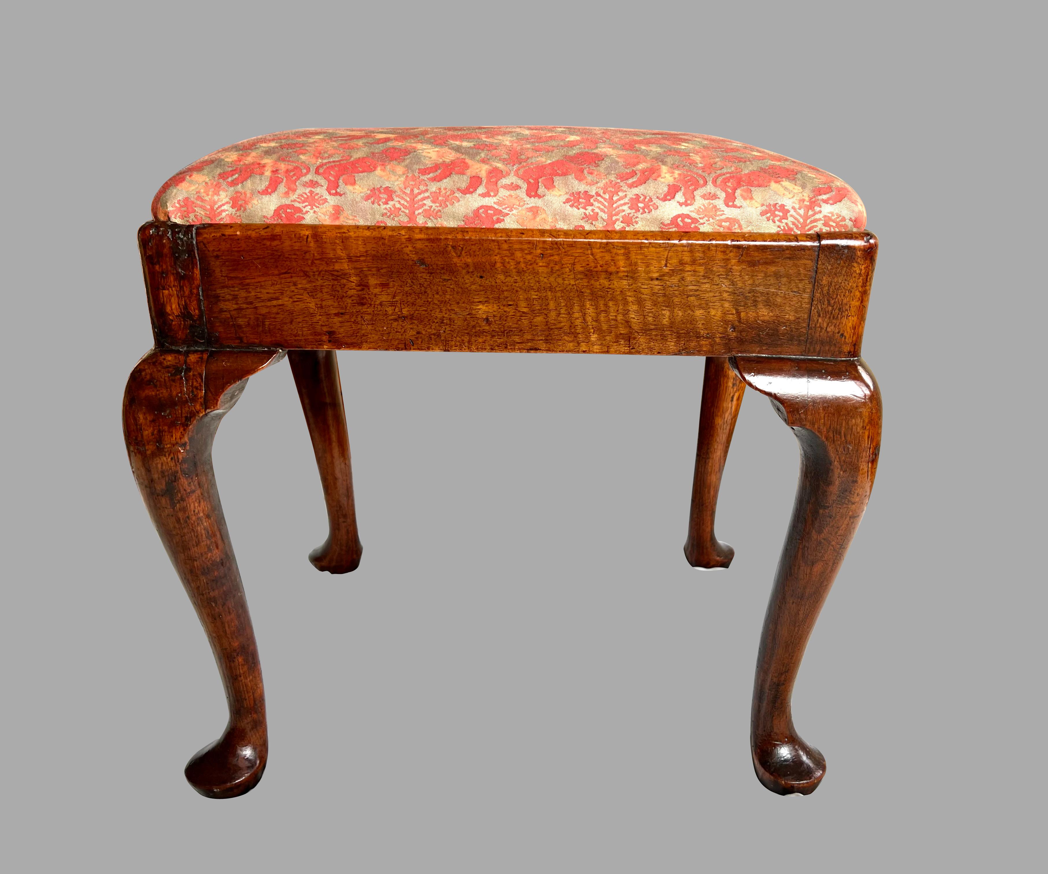 An elegant English George I period mahogany small bench or stool, the cushion inset in a rectangular frame, now upholstered in Fortuny silk, resting on cabriole legs ending in pad feet. Attractive warm nutty brown color. Circa 1730-1750. Old repairs.