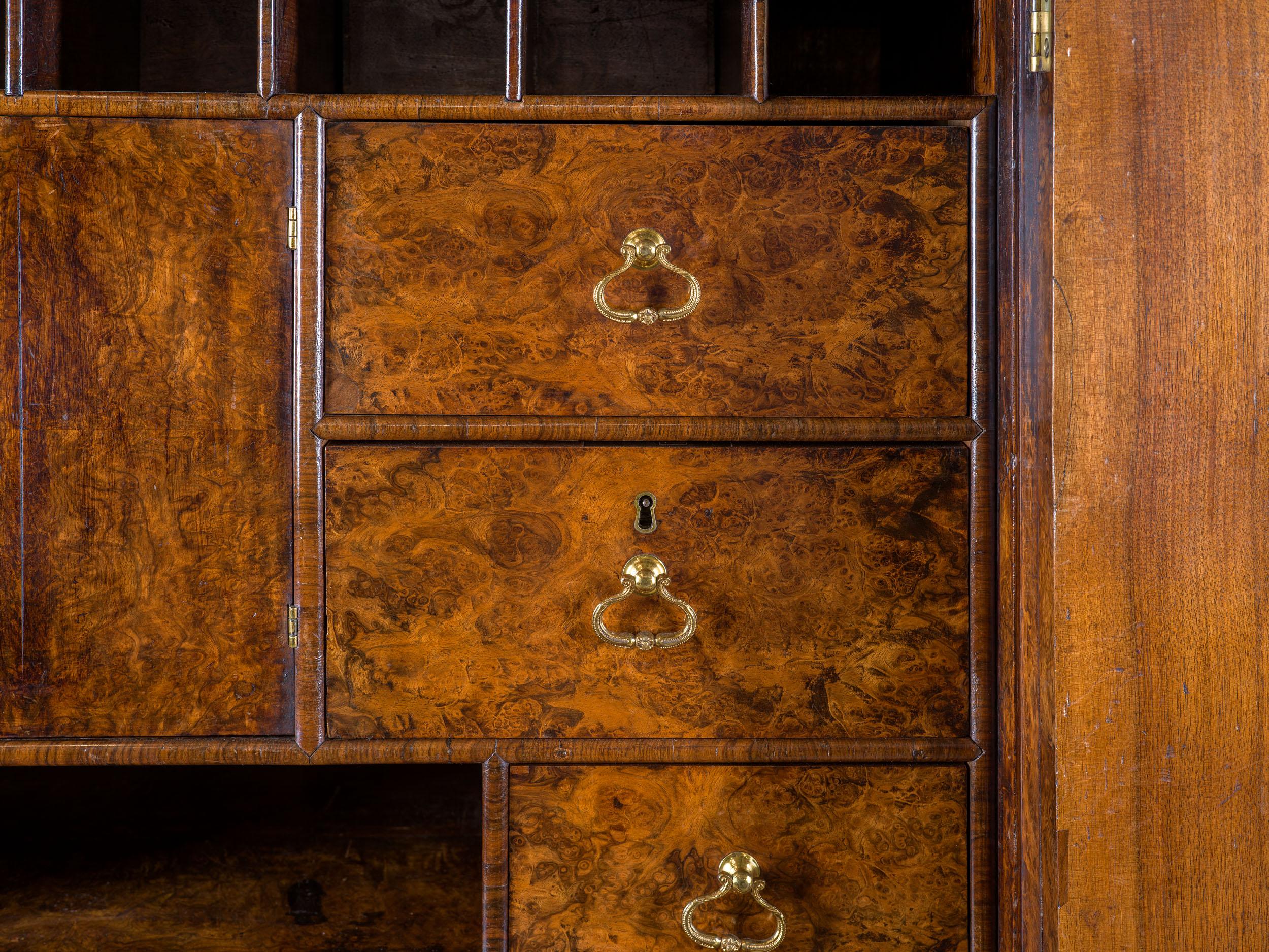 An unusual George I 'mulberry' cabinet in the manner of Coxed and Woster. The cross banded and veneered walnut doors reveal a fine fitted interior which is also beautiful veneered, including a number of hidden drawers, which are beautifully