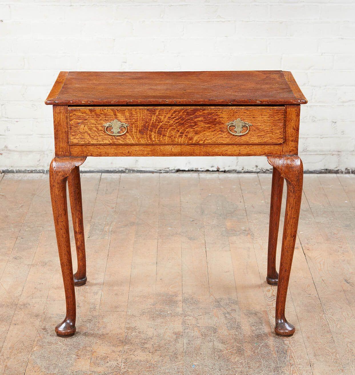 Good George I oak side table, the ogee molded top with mitered breadboard ends, over single drawer with etched brasses, standing on cabriole legs ending in turned pad feet, the whole with mellow pleasing color.