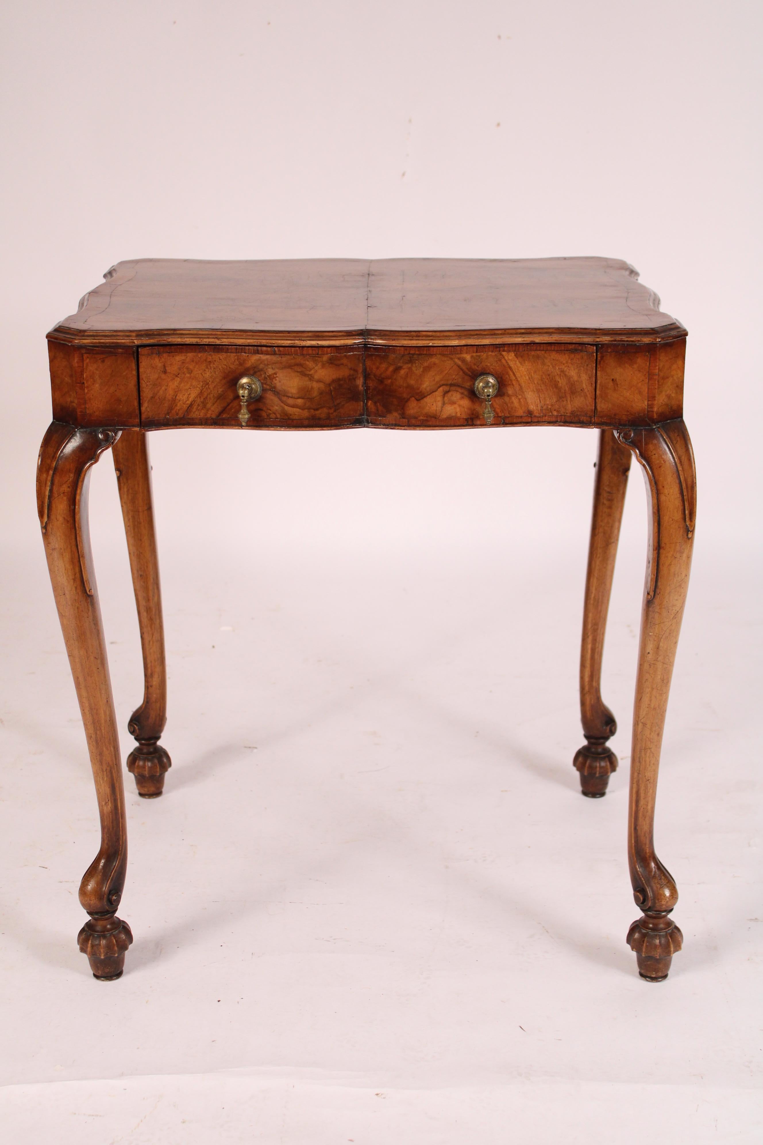 Antique George I Style burl walnut and walnut writing table, circa 1920's.
With a book matched burl walnut top with yew wood crossbanding, the front of the frieze with a drawer with brass hardware the sides and back of the frieze with burl walnut,