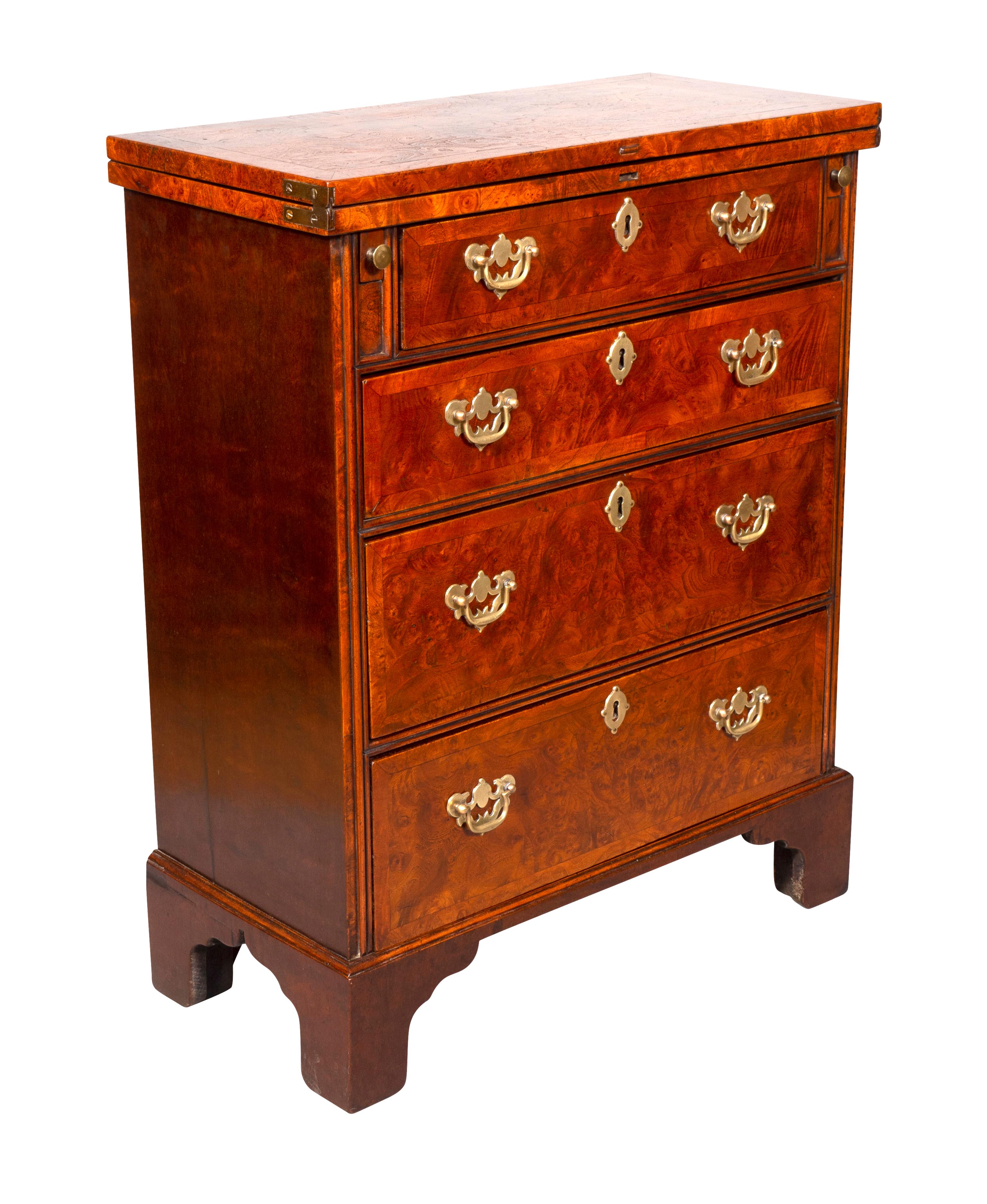 Rectangular hinged top opening to a writing surface over a drawer flanked by lopers to support the top when open over three graduated drawers and bracket feet. Brass hardware.
