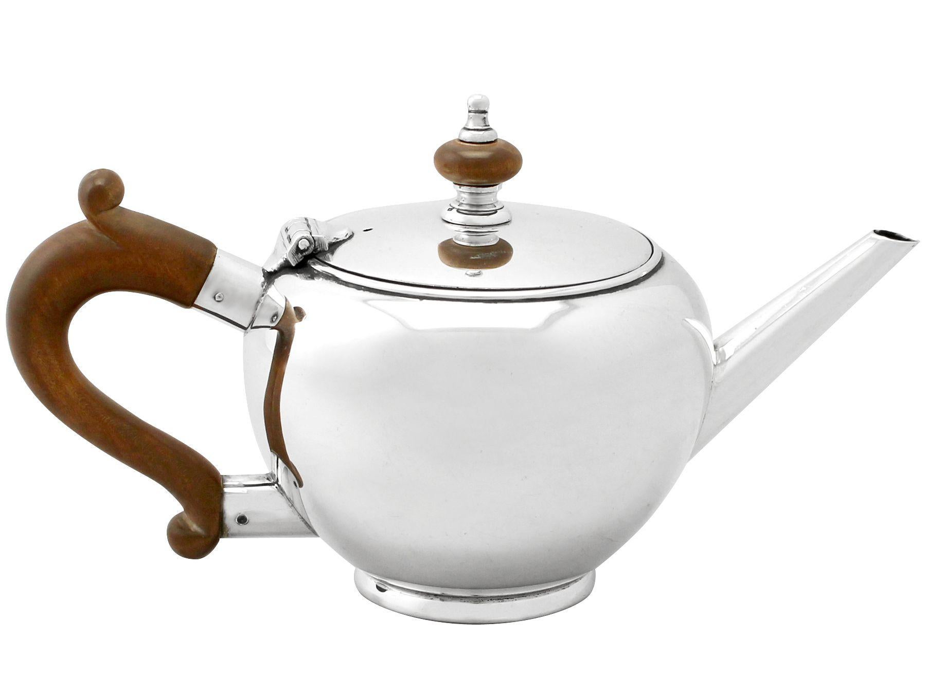 A fine and impressive vintage Elizabeth II English sterling silver bachelor teapot, in the George I style; an addition to our silver teaware collection.

This fine vintage Elizabeth II sterling silver bachelor teapot has a bullet shaped form onto a