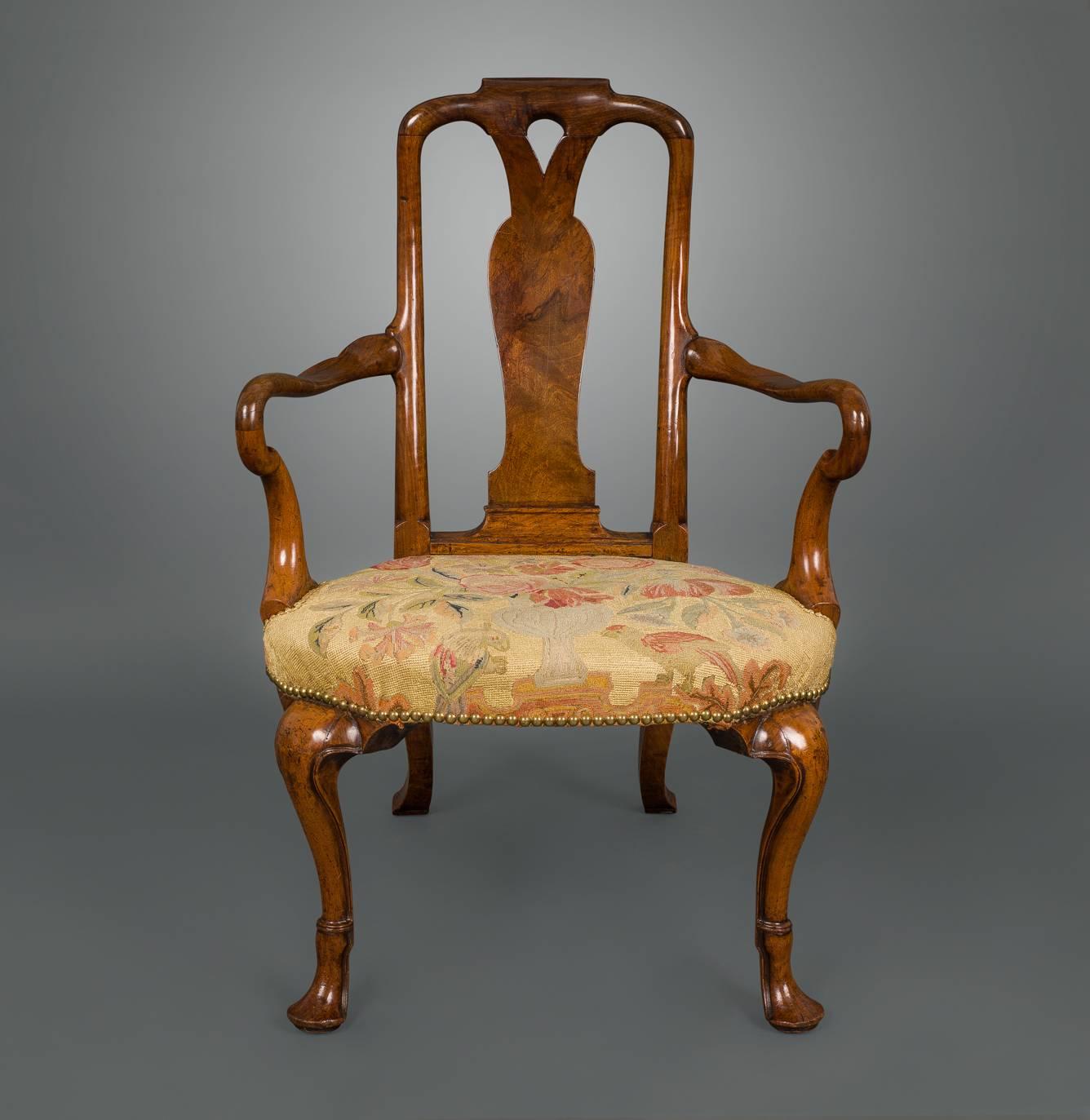 A fine and early walnut chair with wonderfully figured timbers and a superb mellow honey color. With a yoked crest above a pierced and shaped backsplat, the outscrolled shepherd crook arms have a particularly pleasing shape. The seat is a rare