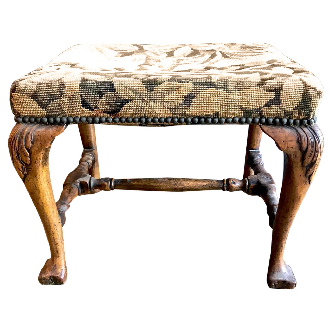 This is a superb example of a George I carved walnut stool that dates to circa 1720. The stool is in very good original condition and is detailed by the original turned stretcher, carved acanthus leaf knees and trifid feet. The Flemish Verdure