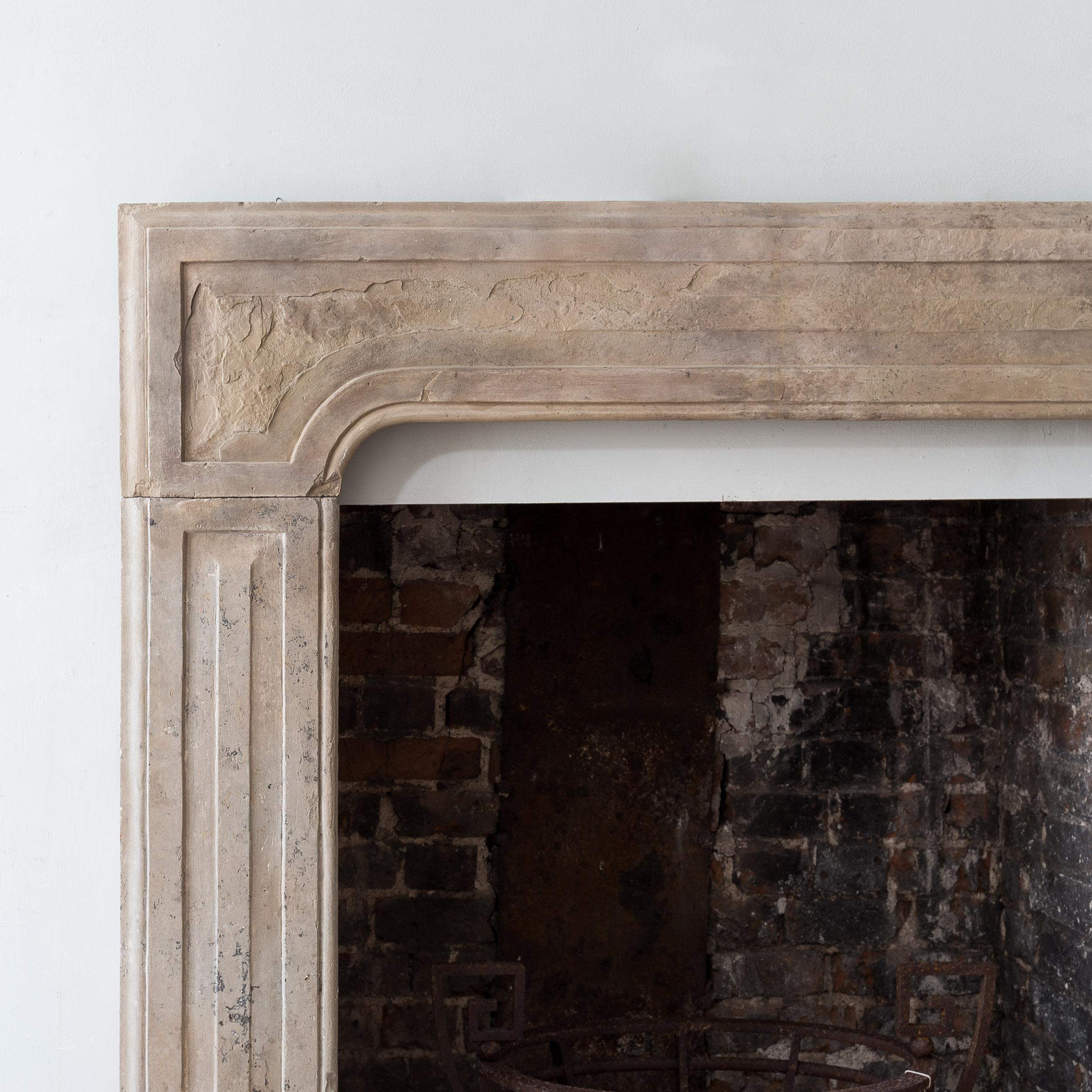 A George I Yorkstone chimneypiece, c.1710-1720, the frame surround with conforming raised panels to the frieze and jambs. Restored.